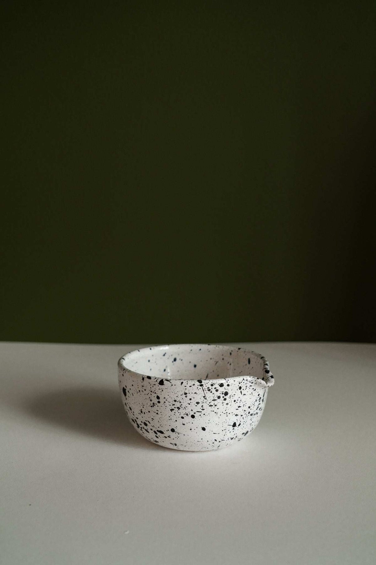 Set of deep stoneware mixing and serving bowls with pour spouts and speckled finish nesting together