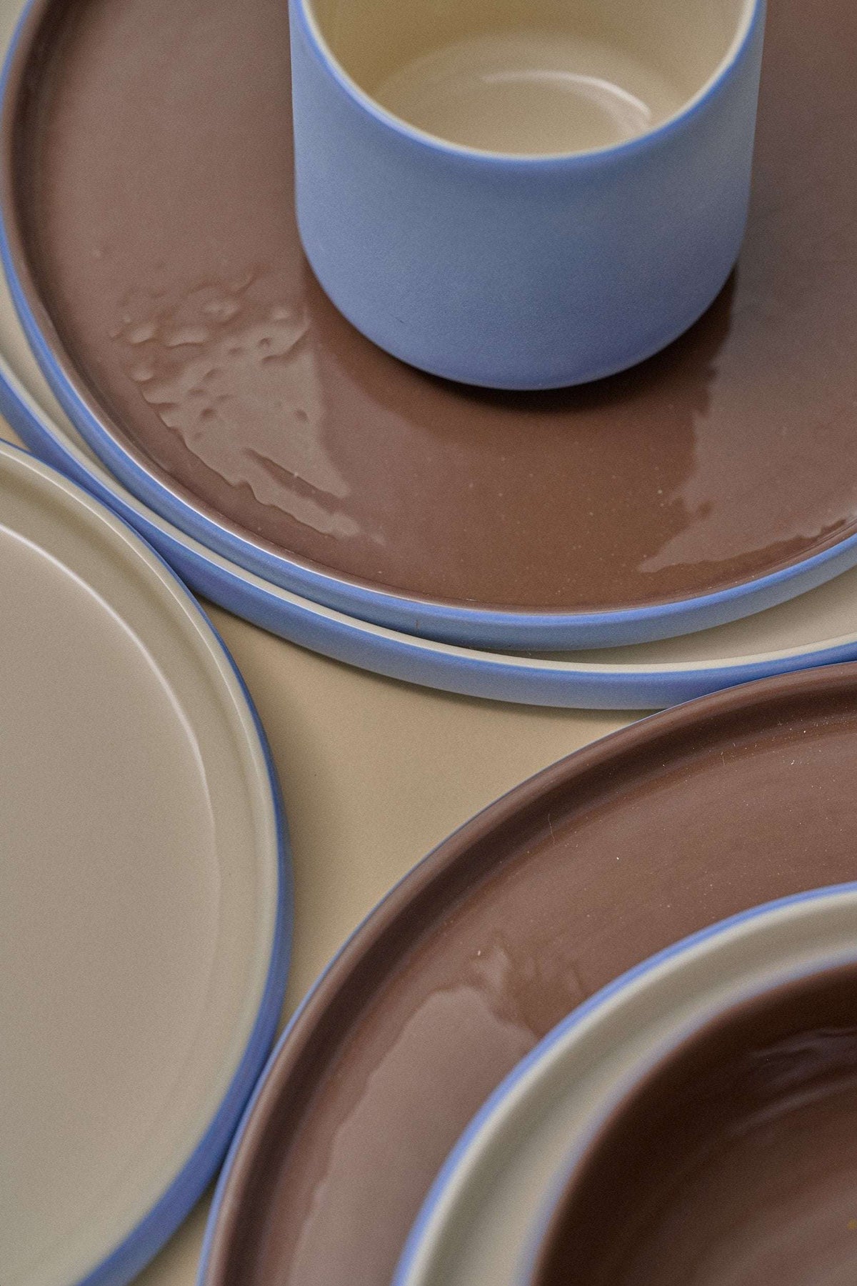 Handmade Blue Porcelain dinner plates with glossy chocolate-brown centers, blue rims, and contrasting cream glaze details.