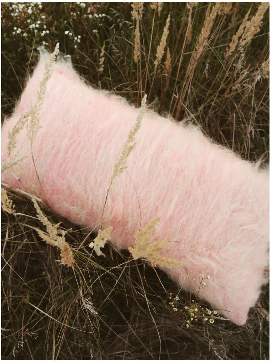 Rectangular pink handwoven wool pillow with brushed texture on cotton base