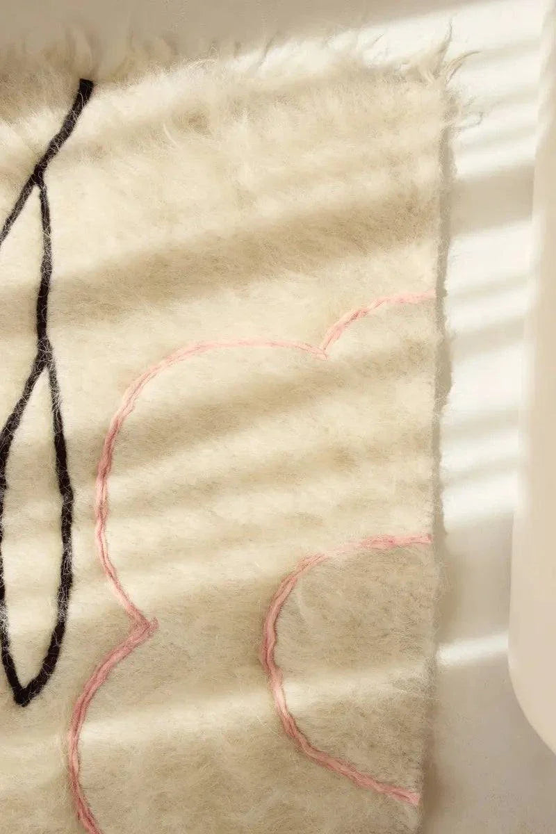 Handwoven wool runner rug with creamy brushed texture and delicate floral outlines