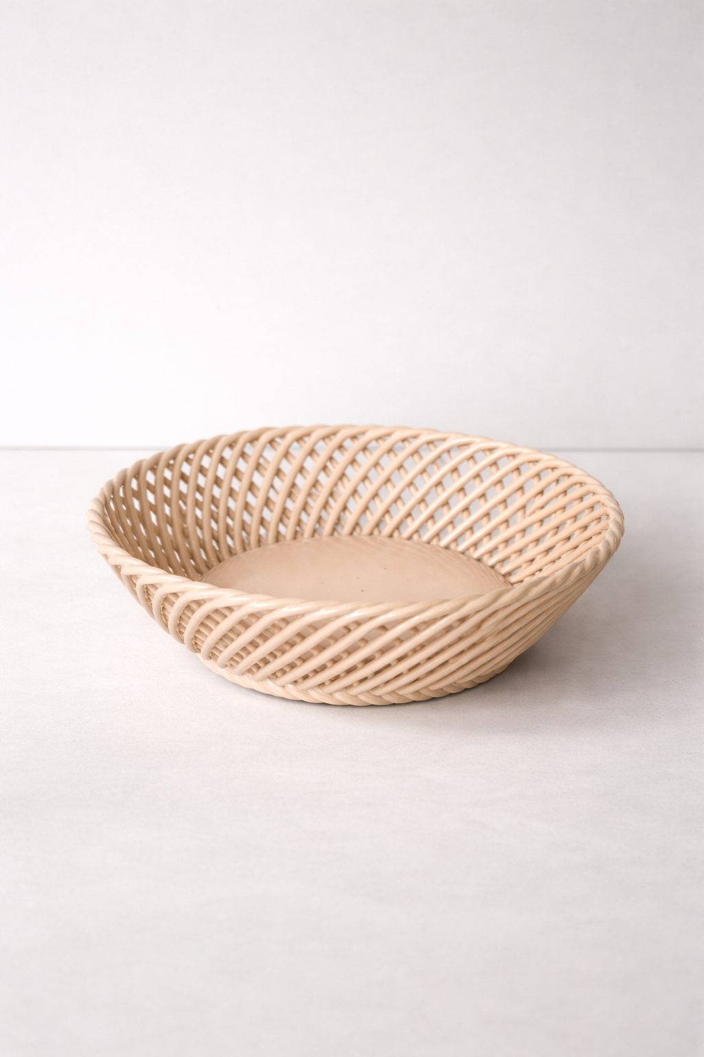 Ceramic Round Hand-Woven Basket in beige glazed ceramic, with an open lattice weave and shallow round shape.