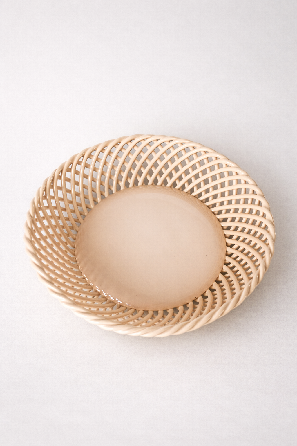 Ceramic Round Hand-Woven Basket in warm beige glazed porcelain, with an airy interlaced rim and smooth solid center.