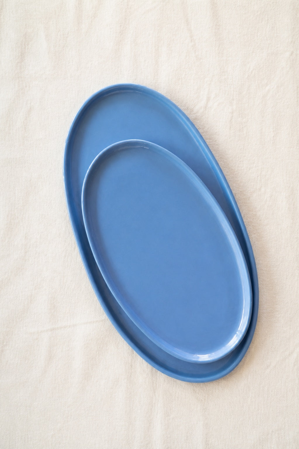 Oval Serving Platter in solid forget-me-not blue porcelain, with a smooth glaze and gently raised organic edges.