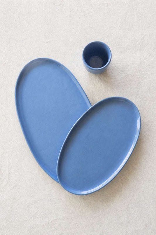 Oval Serving Platter in smooth blue glazed porcelain, handmade with softly irregular edges and a small matching cup.