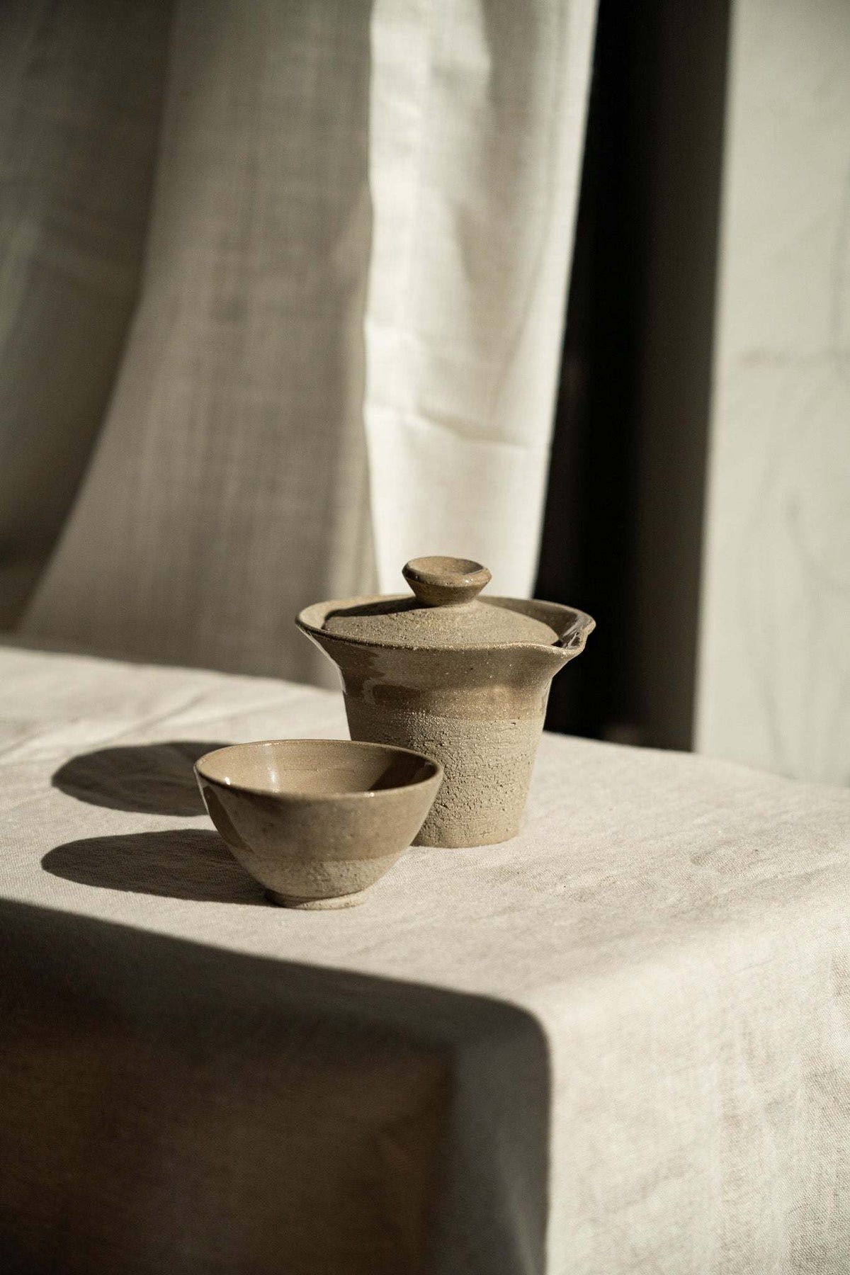 Handmade Stoneware Small Tea Cup in earthy gray-brown, with a speckled, lightly textured exterior and glazed interior.