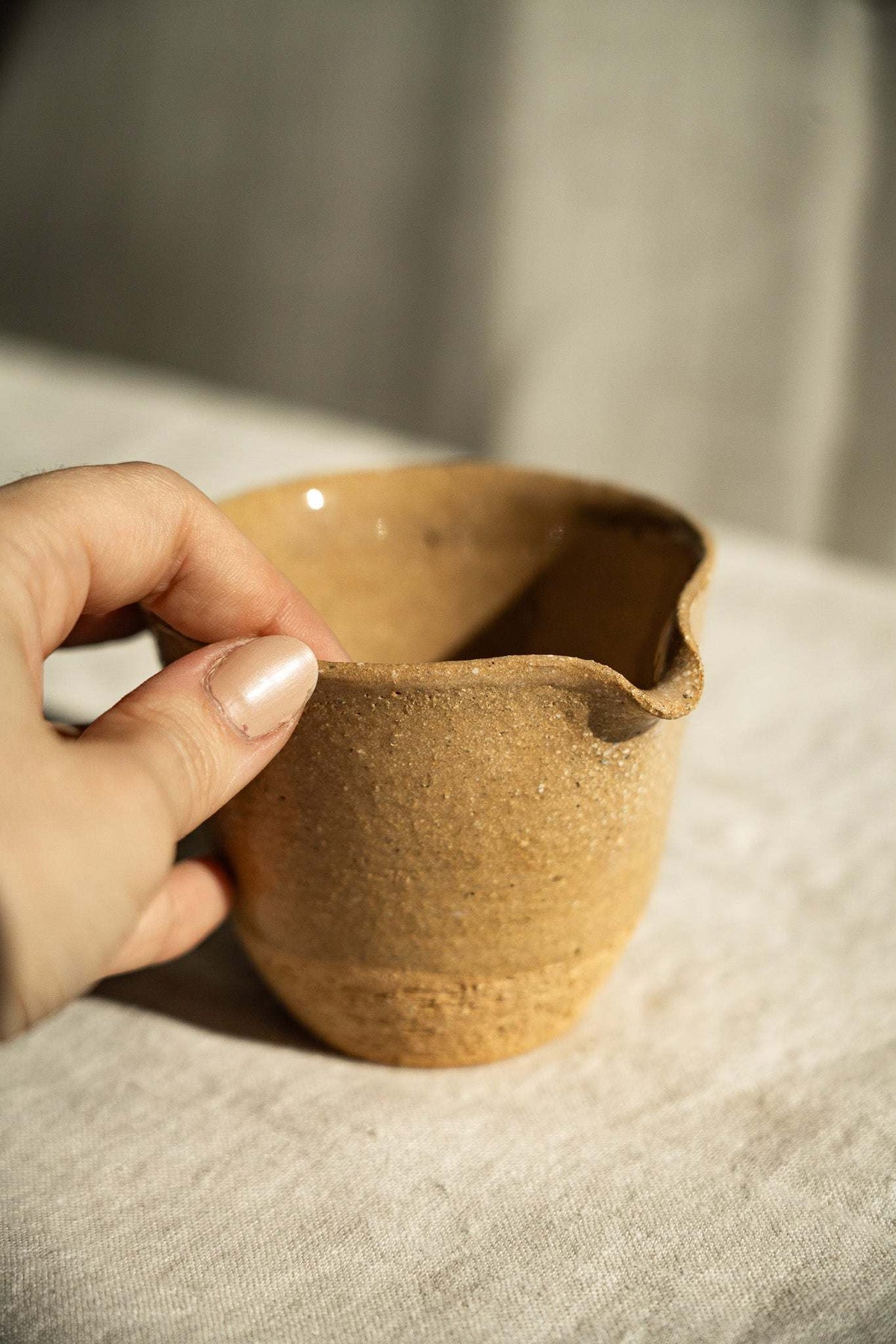 Handmade Stoneware Fair Teacup in warm brown speckled clay, with a glossy interior and sculpted pouring spout.