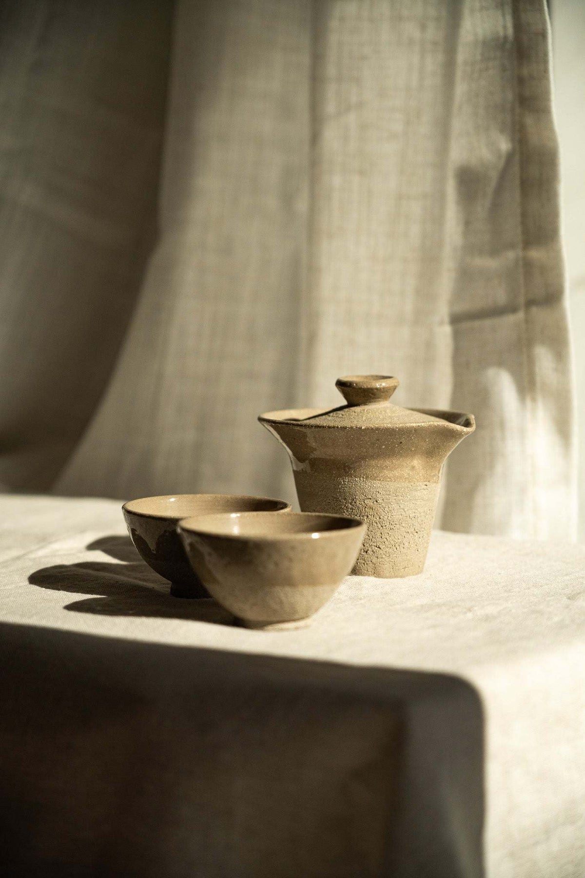 Handmade Stoneware Small Tea Cup in sandy beige with a subtly speckled, matte textured finish and rounded shape.