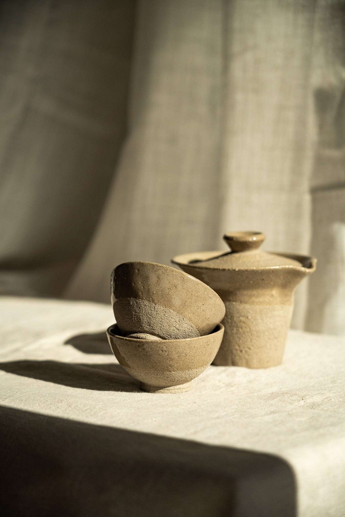 Handmade Stoneware Small Tea Cup in warm beige-gray with a matte, lightly speckled finish and rounded bowl shape.
