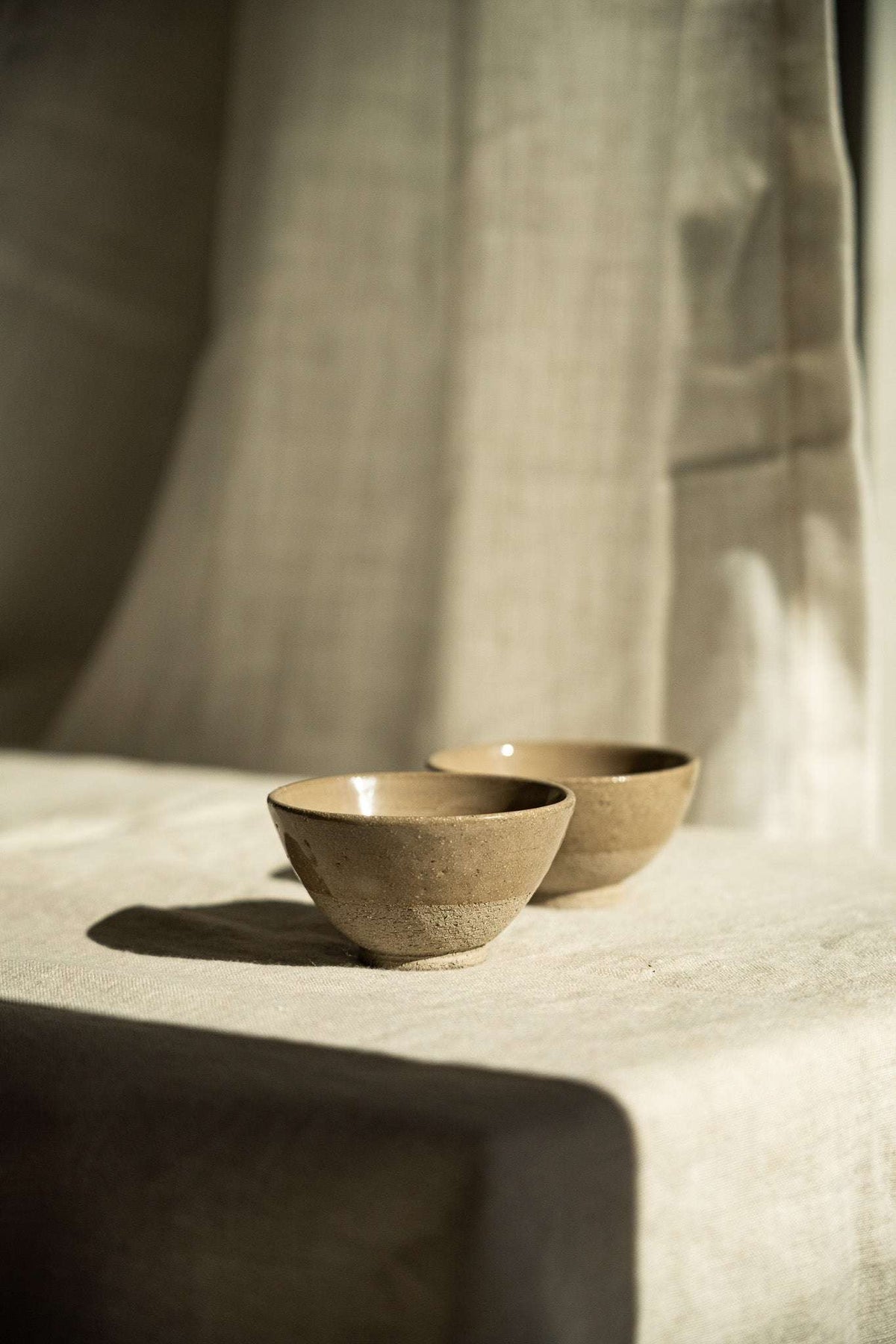 Handmade Stoneware Small Tea Cup in warm gray-brown speckled stoneware, with a rounded bowl and glazed interior.