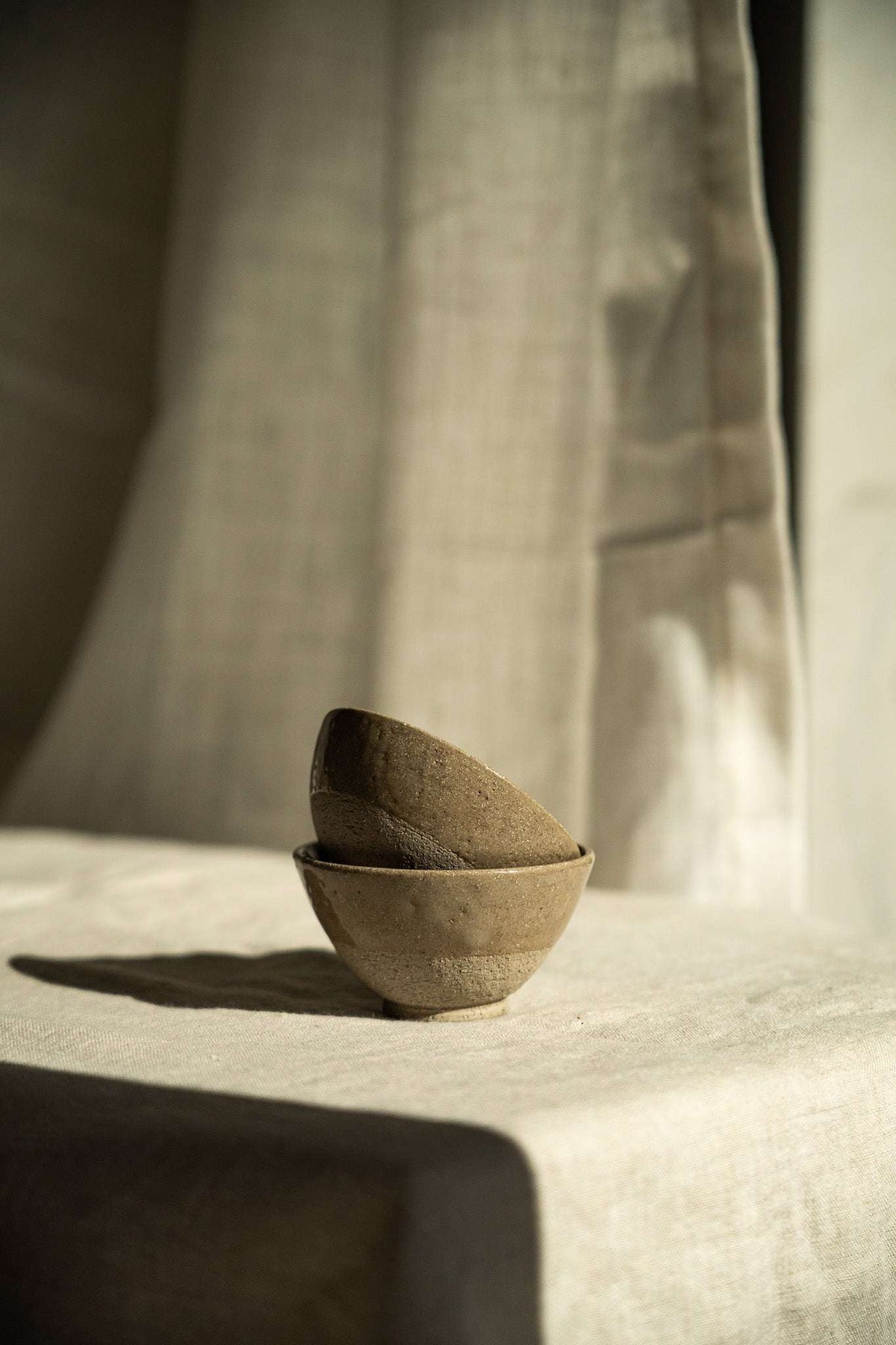 Handmade Stoneware Small Tea Cup in muted gray-brown with a matte, subtly speckled finish and rounded shape.