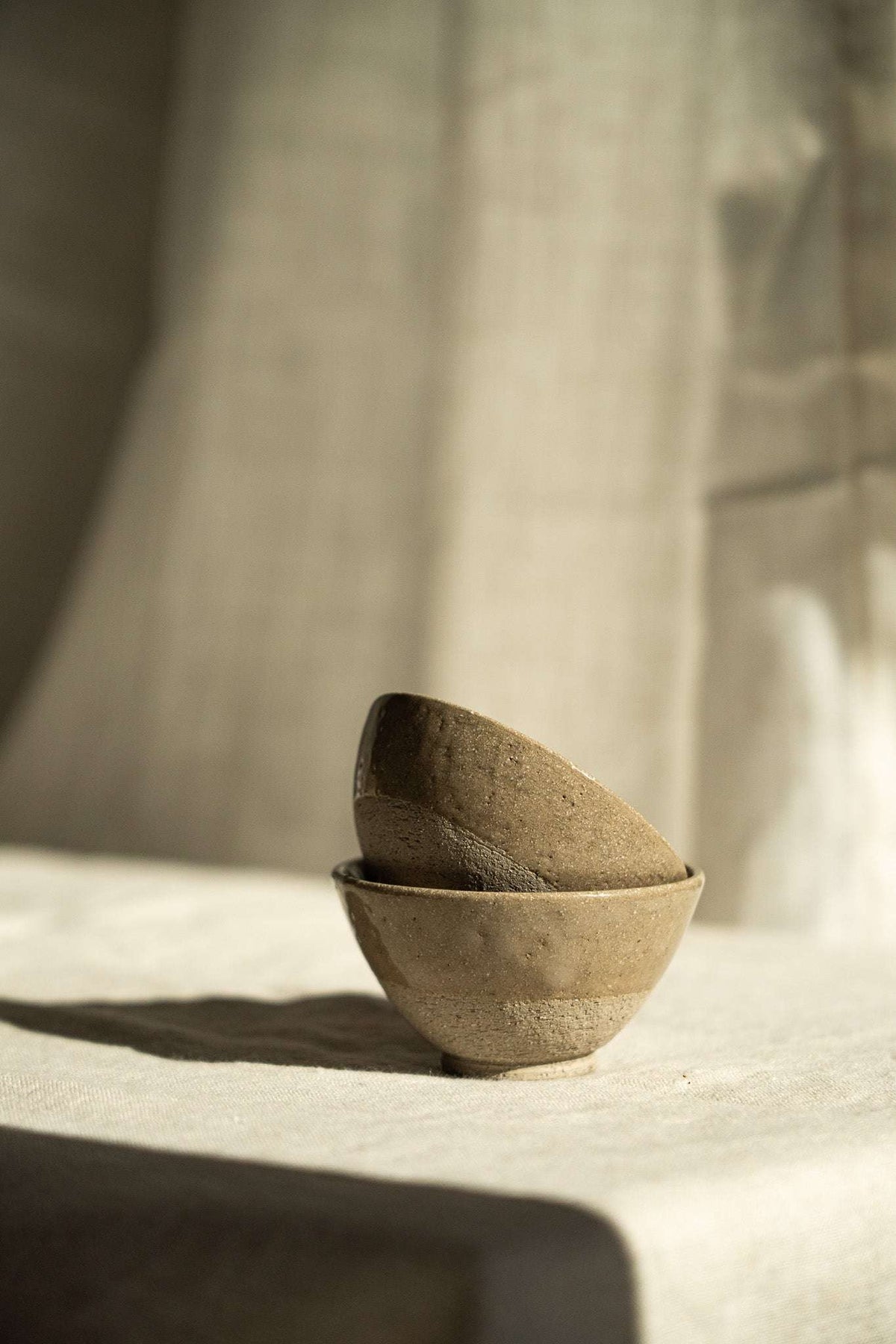 Handmade Stoneware Small Tea Cup in warm gray-brown, with a matte, lightly textured surface and simple rounded shape.