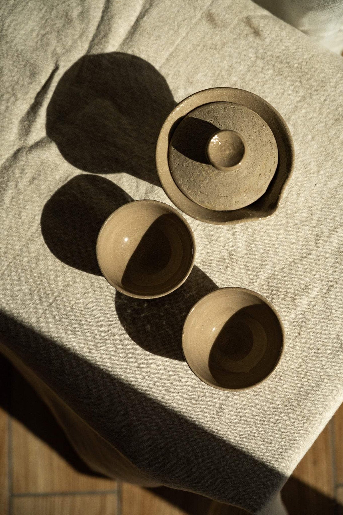 Handmade Stoneware Small Tea Cup with a warm beige glaze, smooth rim, and rounded shape; pictured with two matching cups.