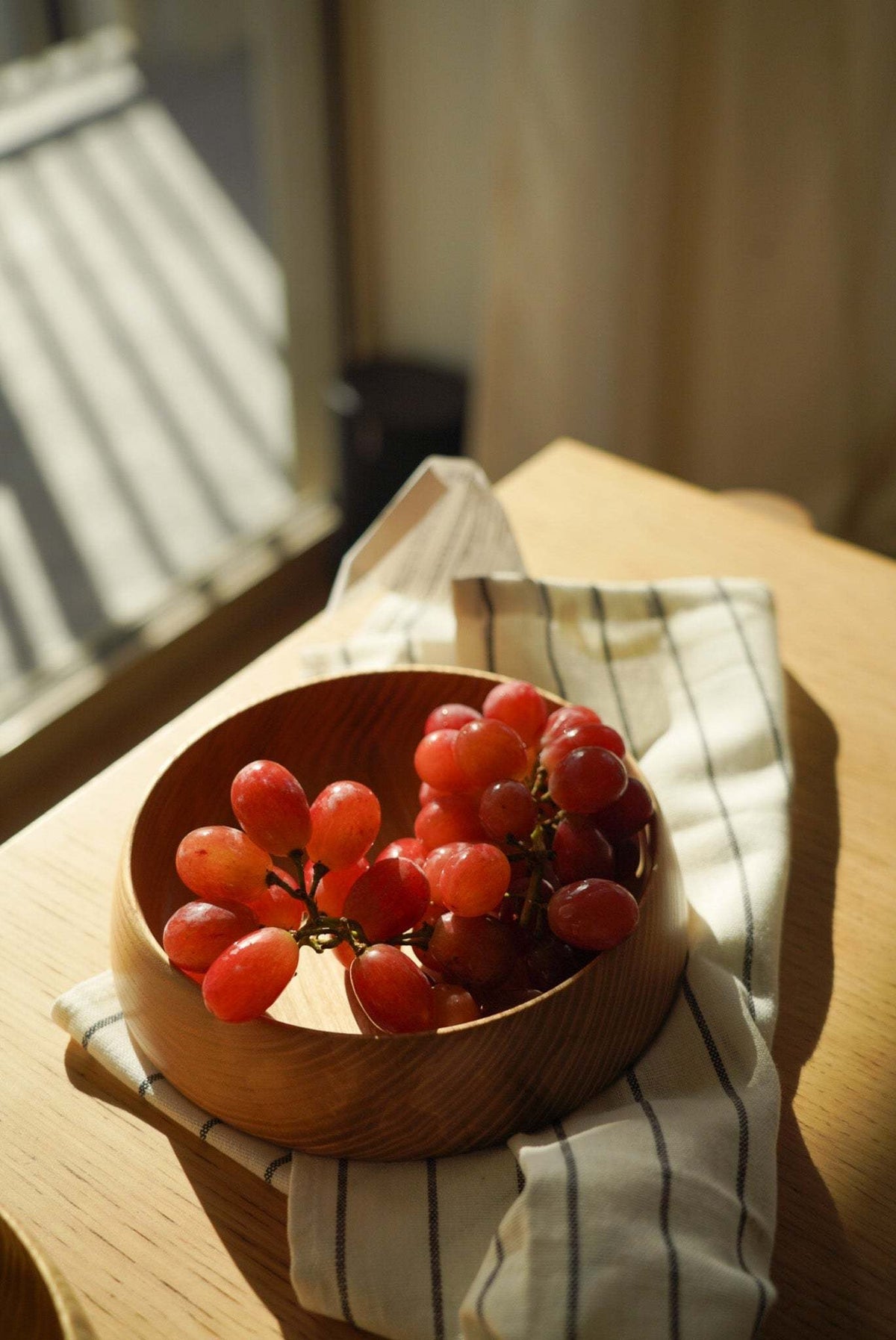 Hand Carved Wooden Plate in warm natural wood with visible grain, rounded high sides, and a carved finish.