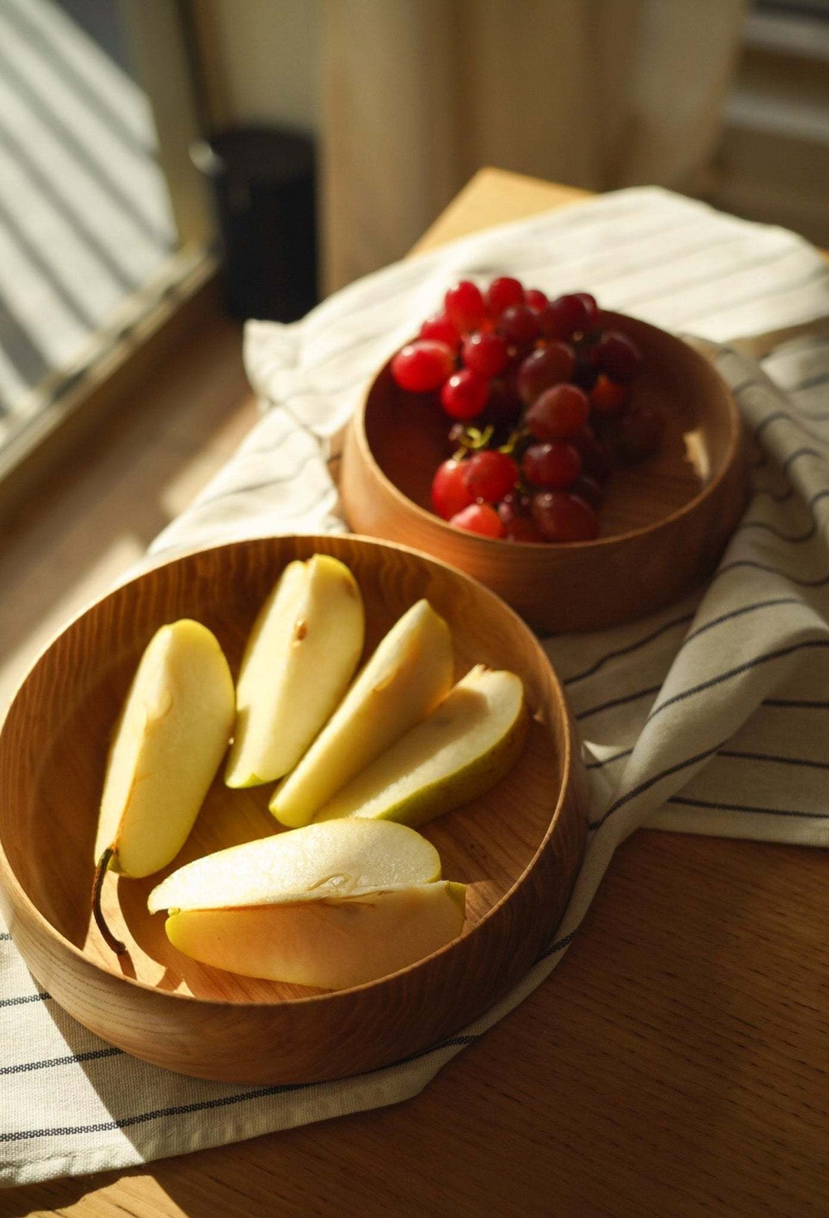 Hand Carved Wooden Plate in warm brown wood with visible grain, rounded high sides and a smooth carved finish.