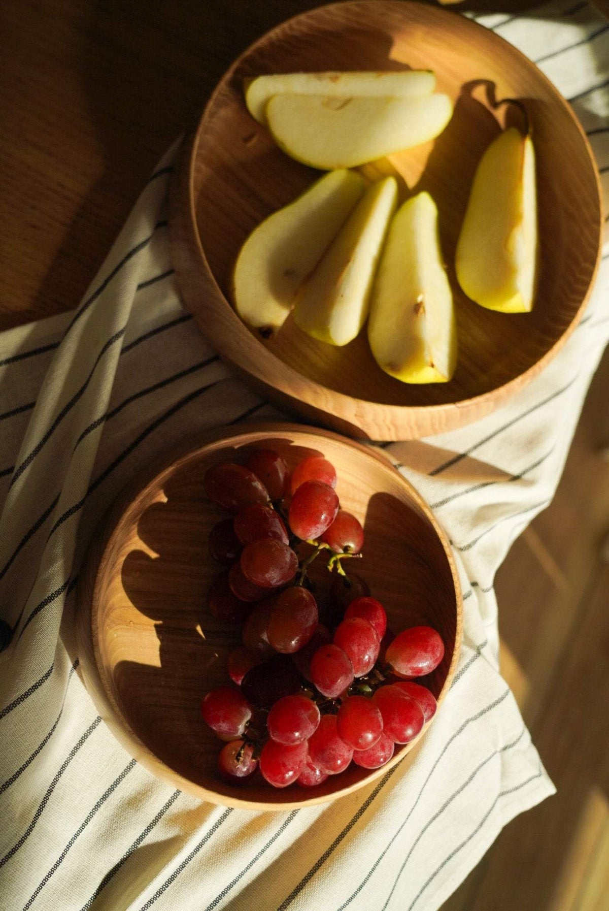 Hand Carved Wooden Plate in warm natural ash wood with visible grain, rounded high sides and a smooth carved finish.