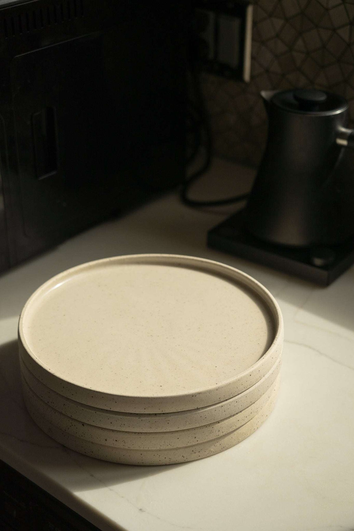 Stoneware Pottery Plate in warm white speckled stoneware, with a raised rim and subtly ridged sides.