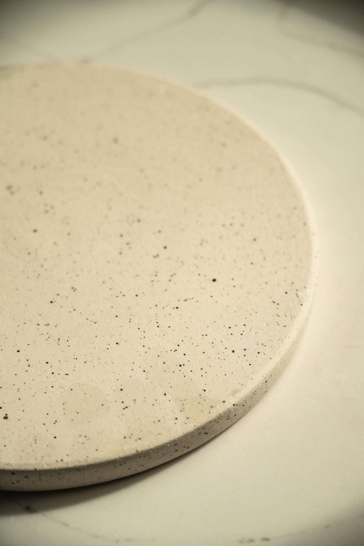 Stoneware Pottery Plate in creamy white speckled stoneware, with a shallow rounded rim and matte, natural finish.