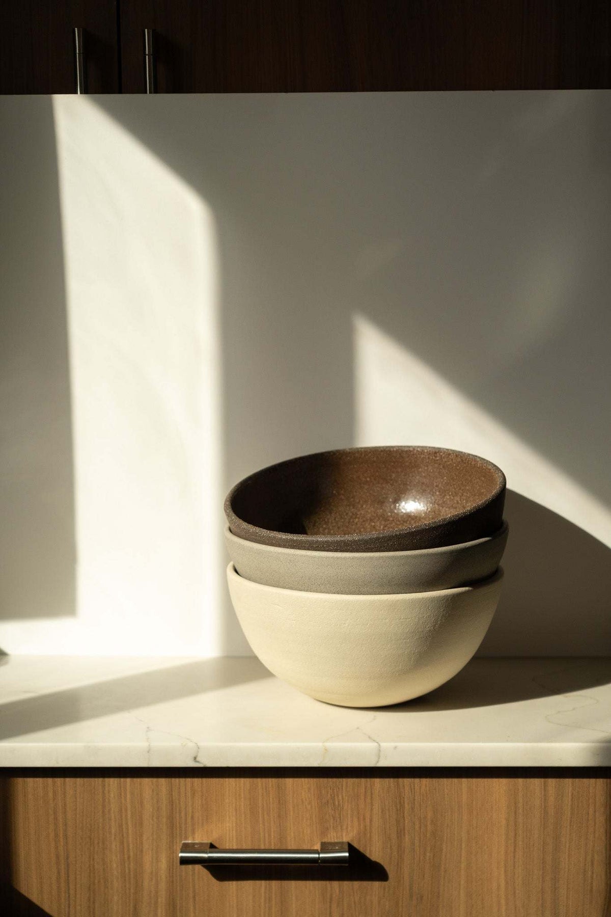 Stoneware Large Fruit Bowl in cream with a dark brown glazed interior and subtly textured, rounded form.