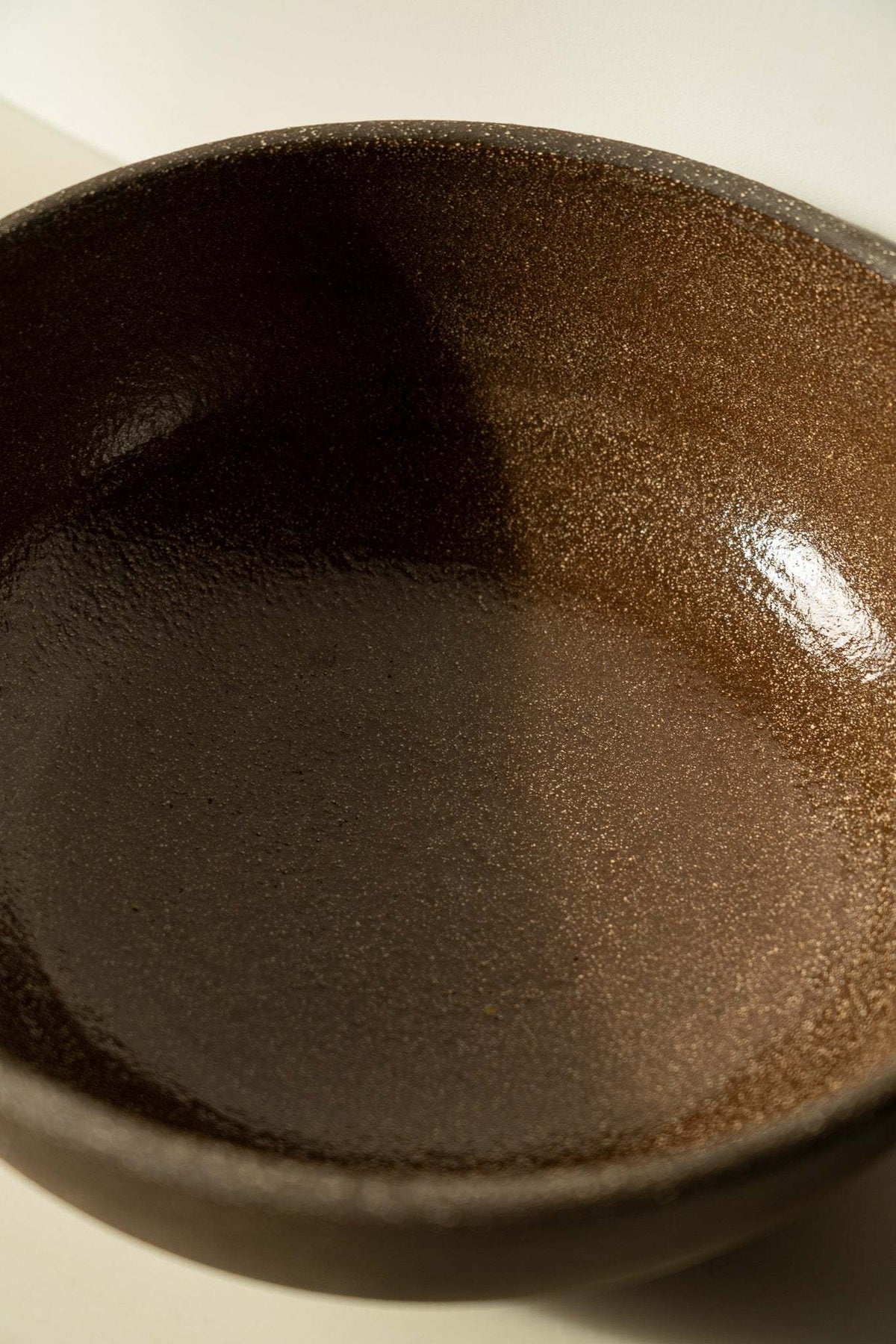 Stoneware Large Fruit Bowl with a deep dark brown speckled glaze, rounded shape, and textured rim

