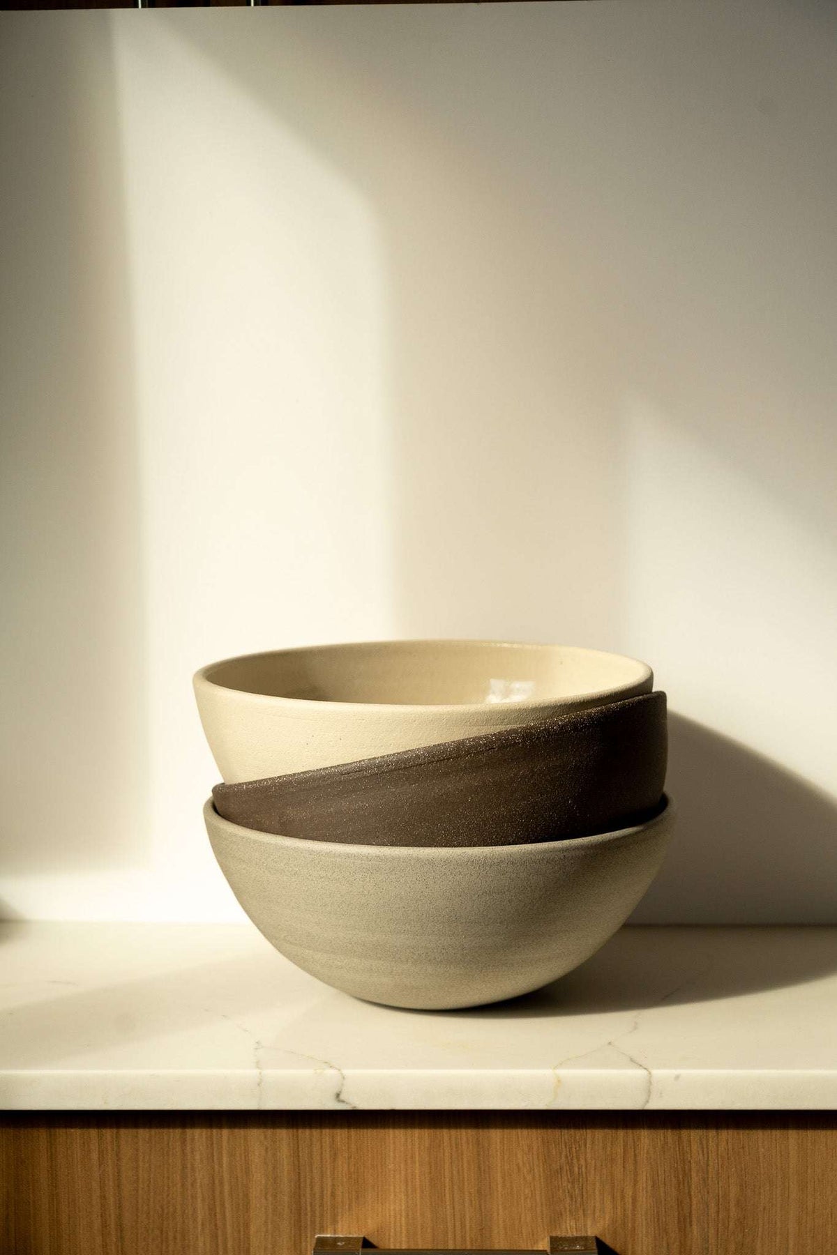 Stoneware Large Fruit Bowl in layered beige and dark brown, with a smooth glazed interior and rounded shape.