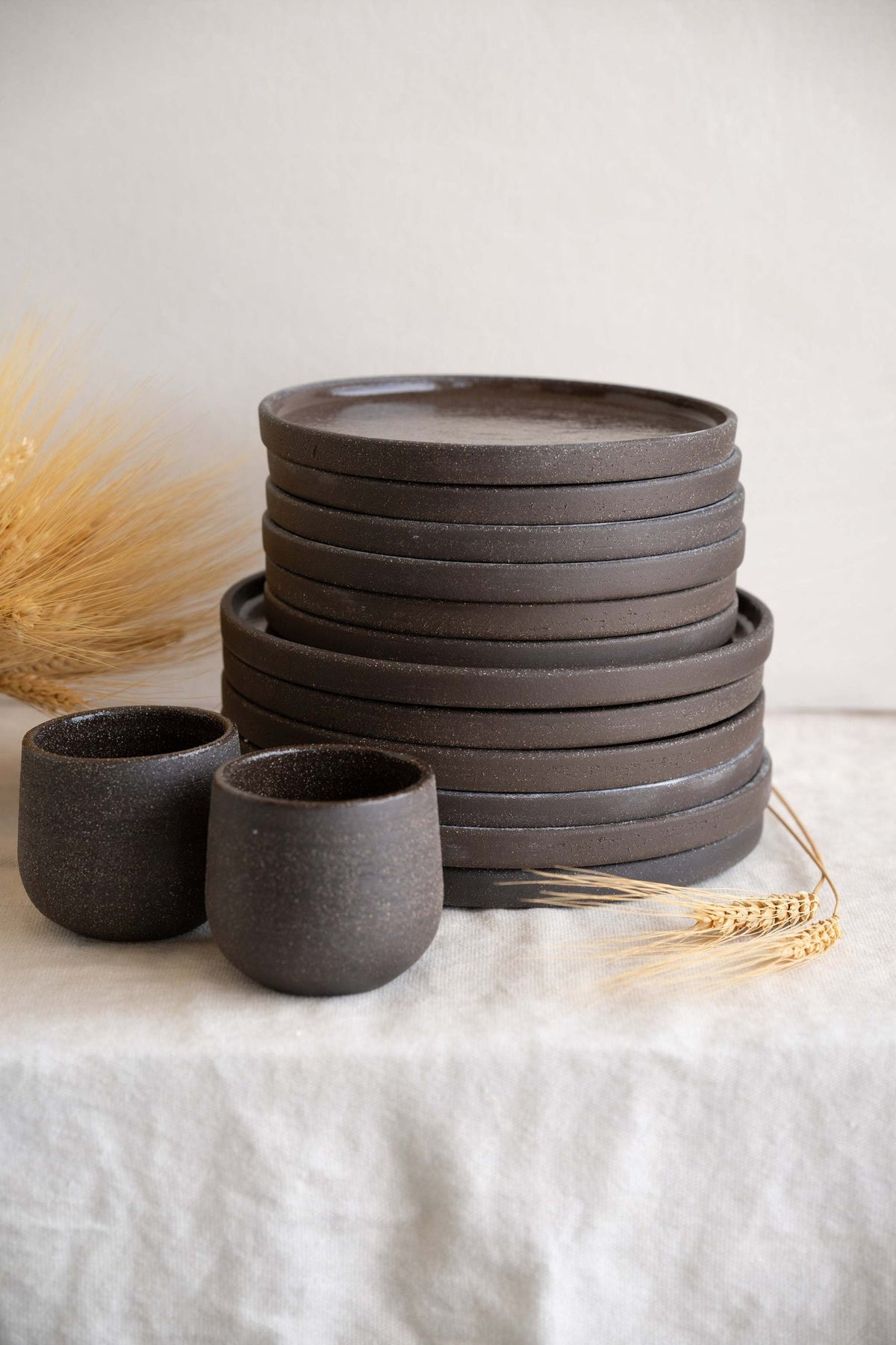 Handmade stoneware dinner plates in dark pumpernickel color with smooth glazed interior and rough exterior