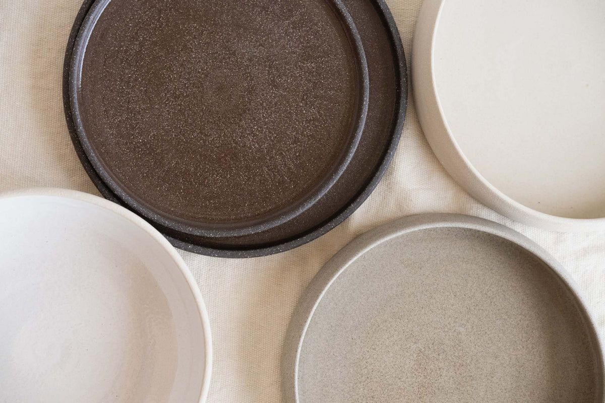 Handmade stoneware dinner plates in dark pumpernickel color with smooth glazed interior and rough exterior