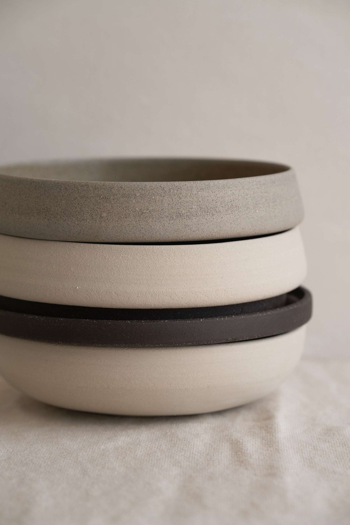 Handmade stoneware dinner plates in pumpernickel color with smooth glazed interior and rough exterior