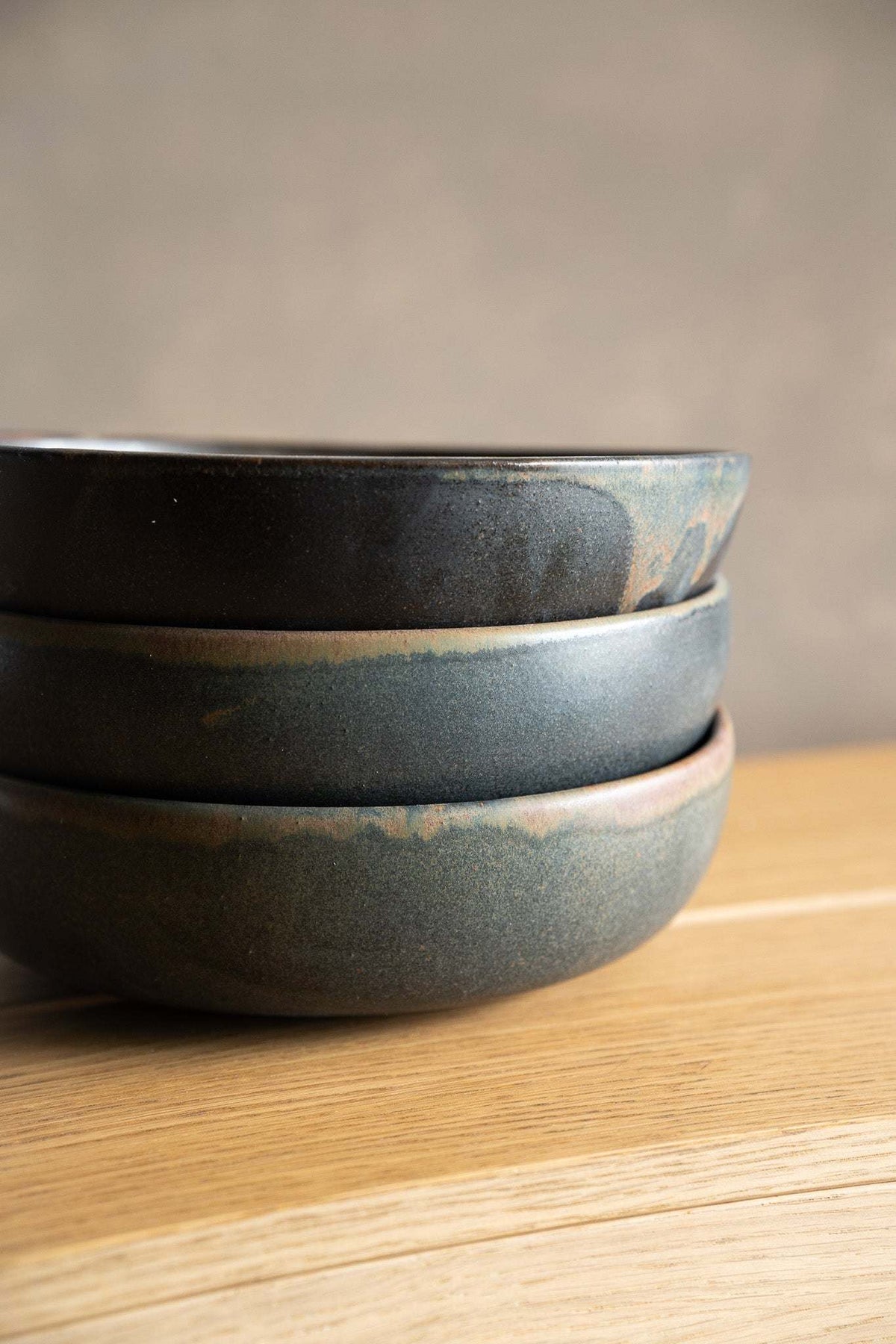 Stoneware pasta bowl in blue-gray matte glaze, with earthy reactive mottling and a gently irregular rim.