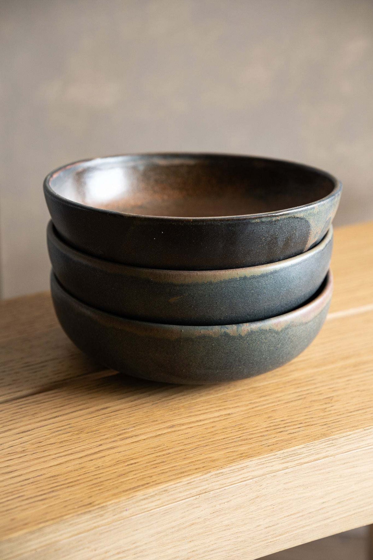 Stoneware pasta bowl set in dark charcoal and blue-gray stoneware with subtle mottled glaze and rounded rims.