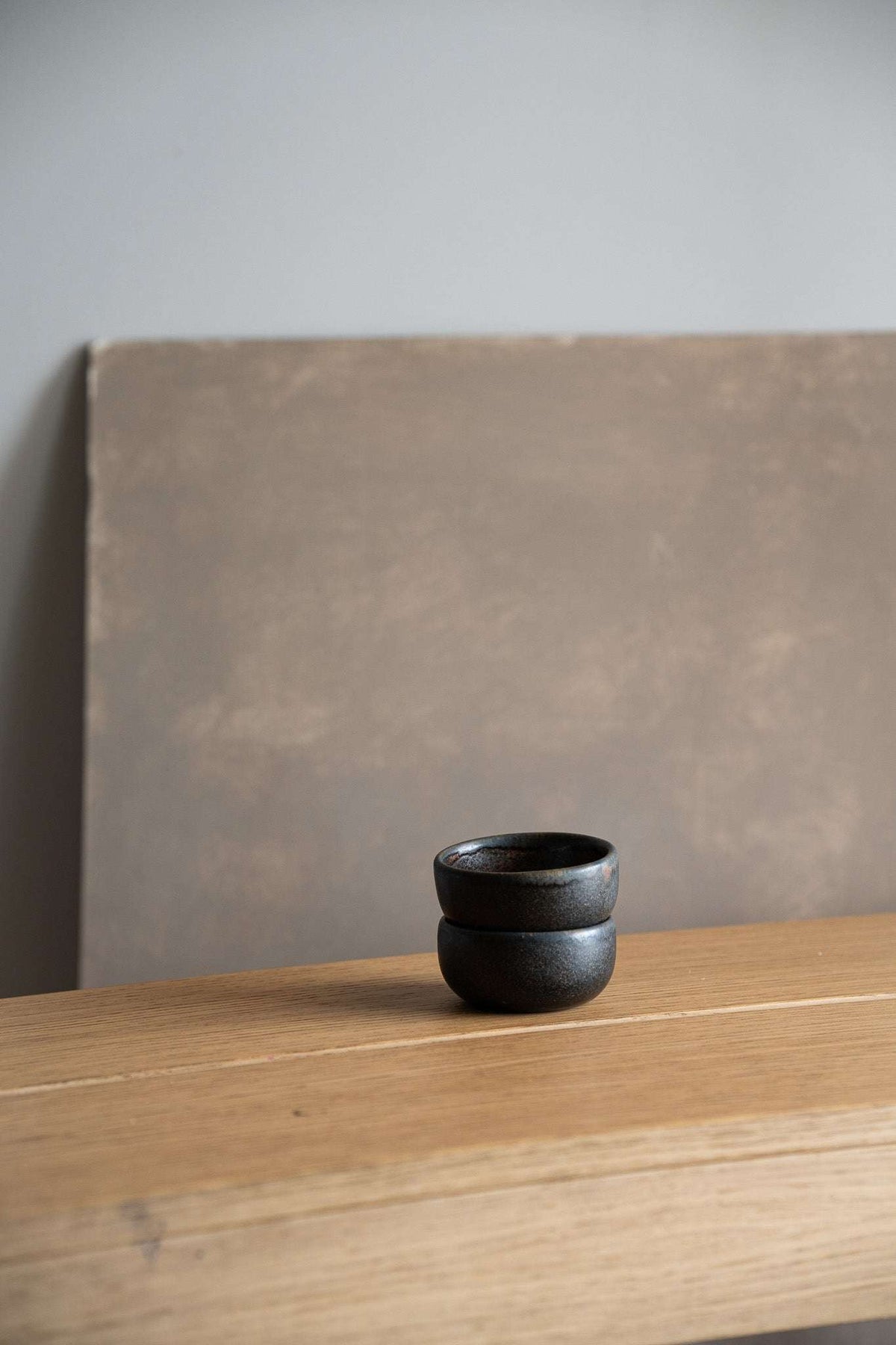 Rust Stoneware Pinch Bowl in dark charcoal glaze, rounded double-lobed shape with a smooth, subtly textured finish.