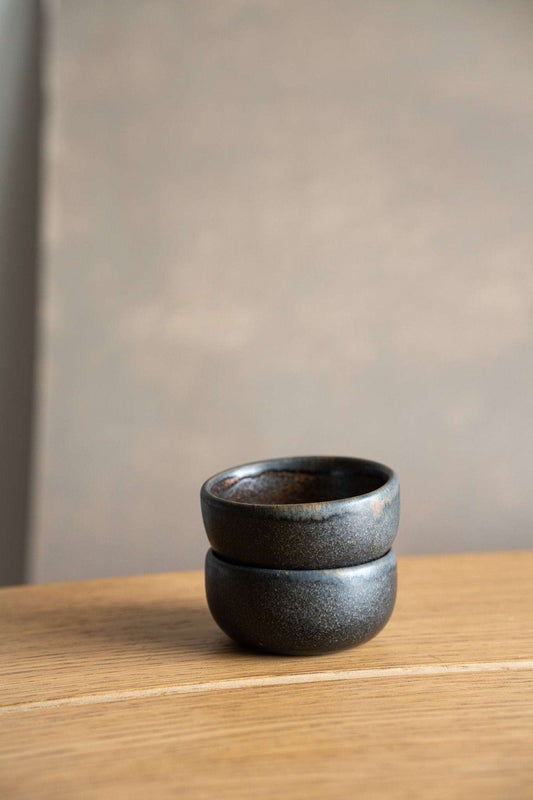 Rust Stoneware Pinch Bowl with a rounded shape, dark charcoal glaze, subtle speckling, and a warm brown rim.