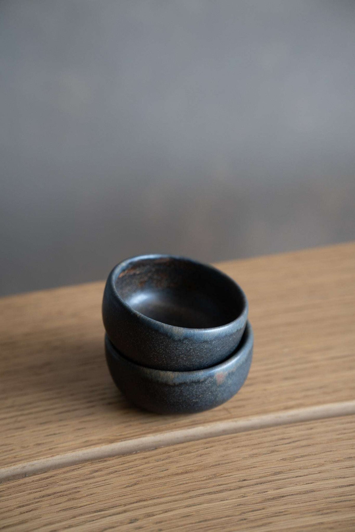 Rust Stoneware Pinch Bowl in dark charcoal stoneware with a subtle blue-gray speckled glaze and rounded rim.