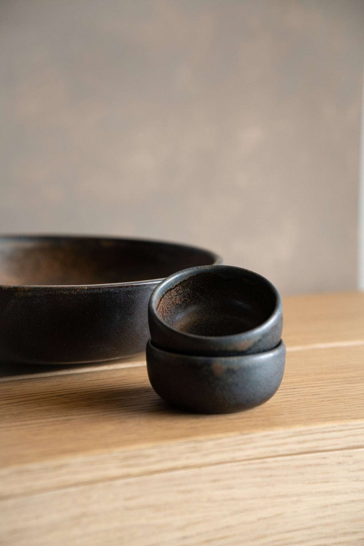 Rust Stoneware Pinch Bowl, small round bowl in dark charcoal stoneware with a smooth, subtly mottled glaze and raised rim.