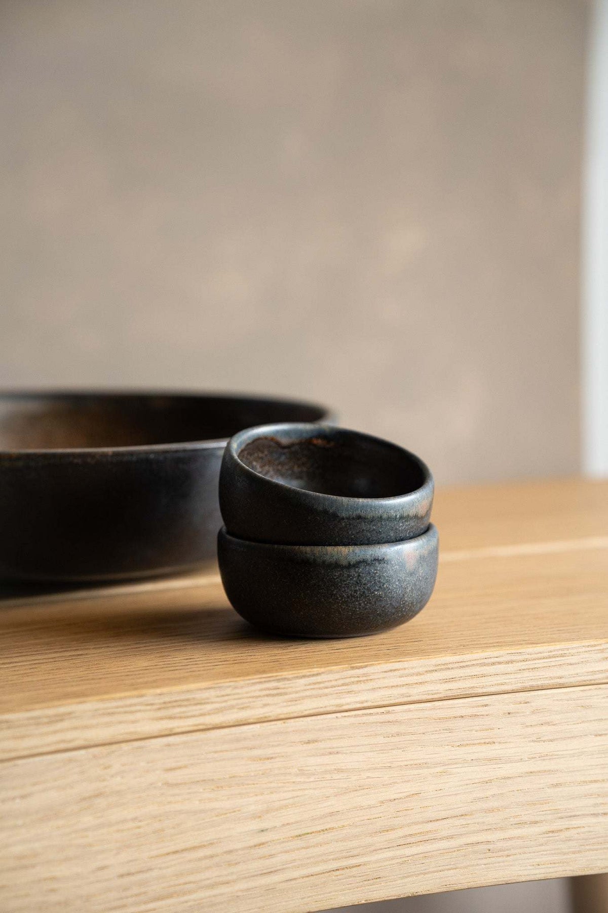 Rust Stoneware Pinch Bowl in charcoal-gray stoneware with a dark glazed interior and rounded, stacked profile.