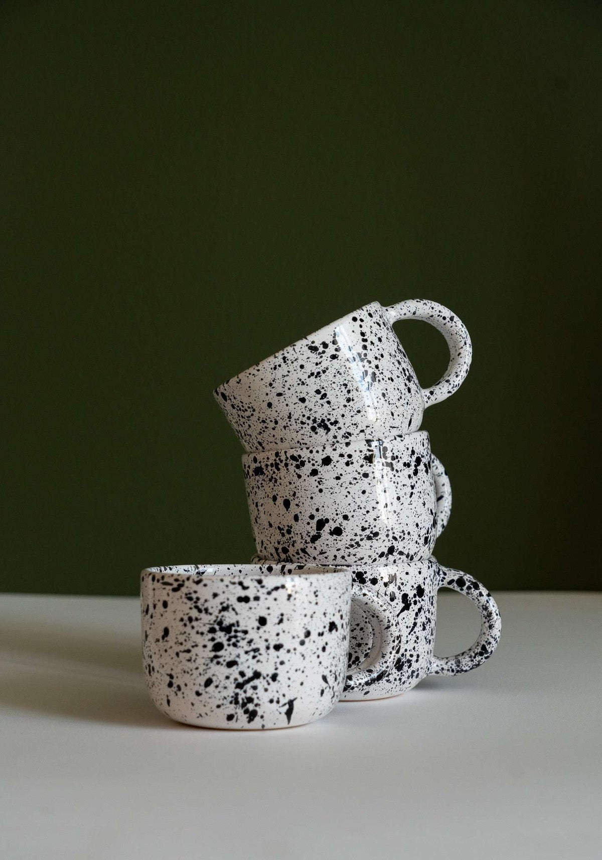 Hand painted personalized stoneware ceramic mug with double handle featuring splatter glaze design
