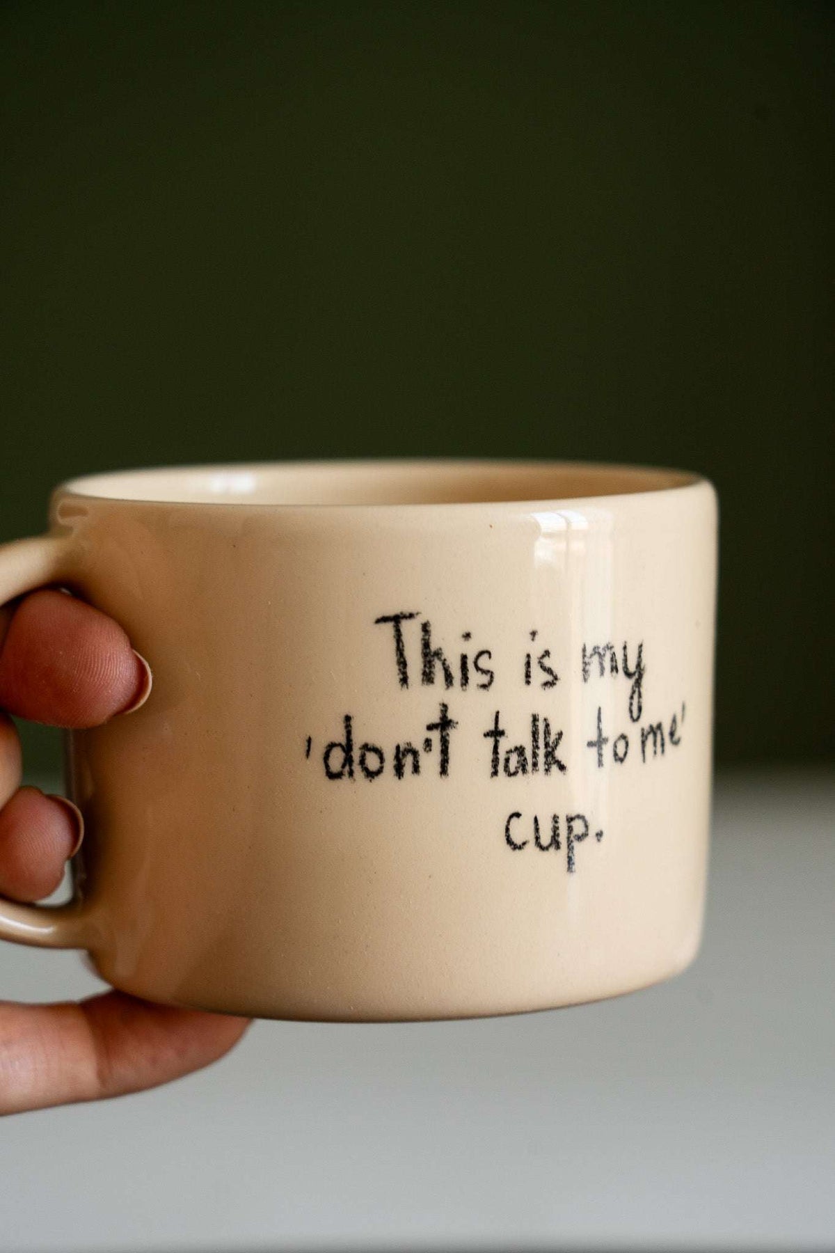 Personalized Stoneware Mug in pale beige ceramic with a rounded handle and handwritten black “don't talk to me” message.