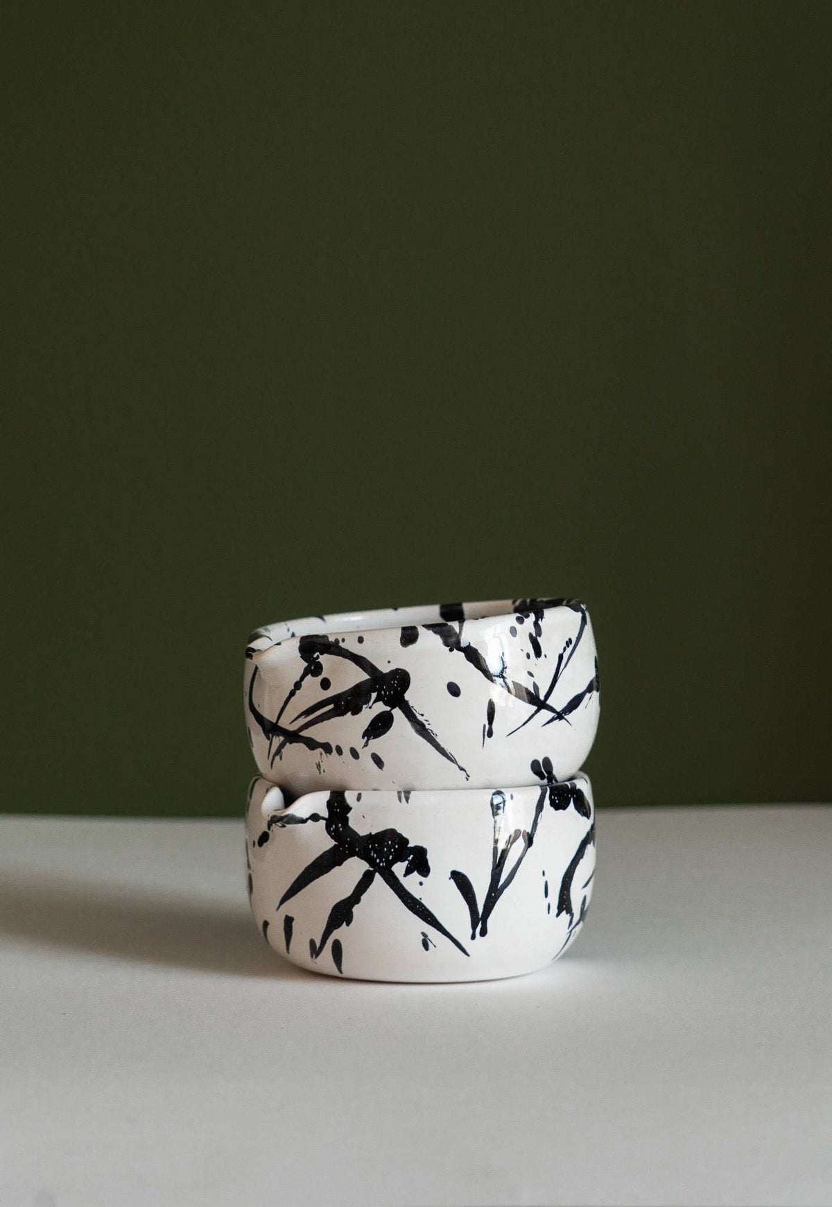 Handmade Matcha Bowl in white stoneware with bold black brushstroke splashes and a rounded, handmade shape.