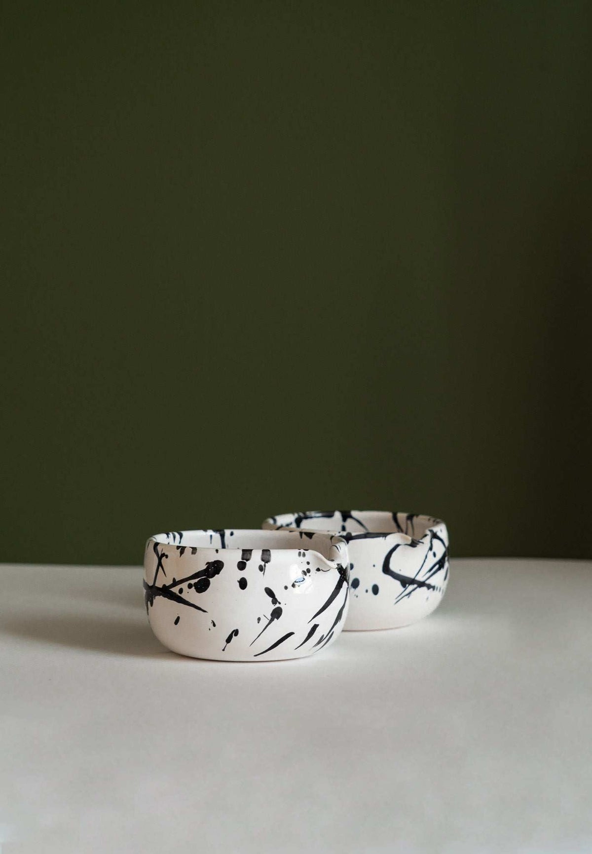 Handmade Matcha Bowl, white ceramic with bold black splatter strokes and a rounded shape, shown in a pair.