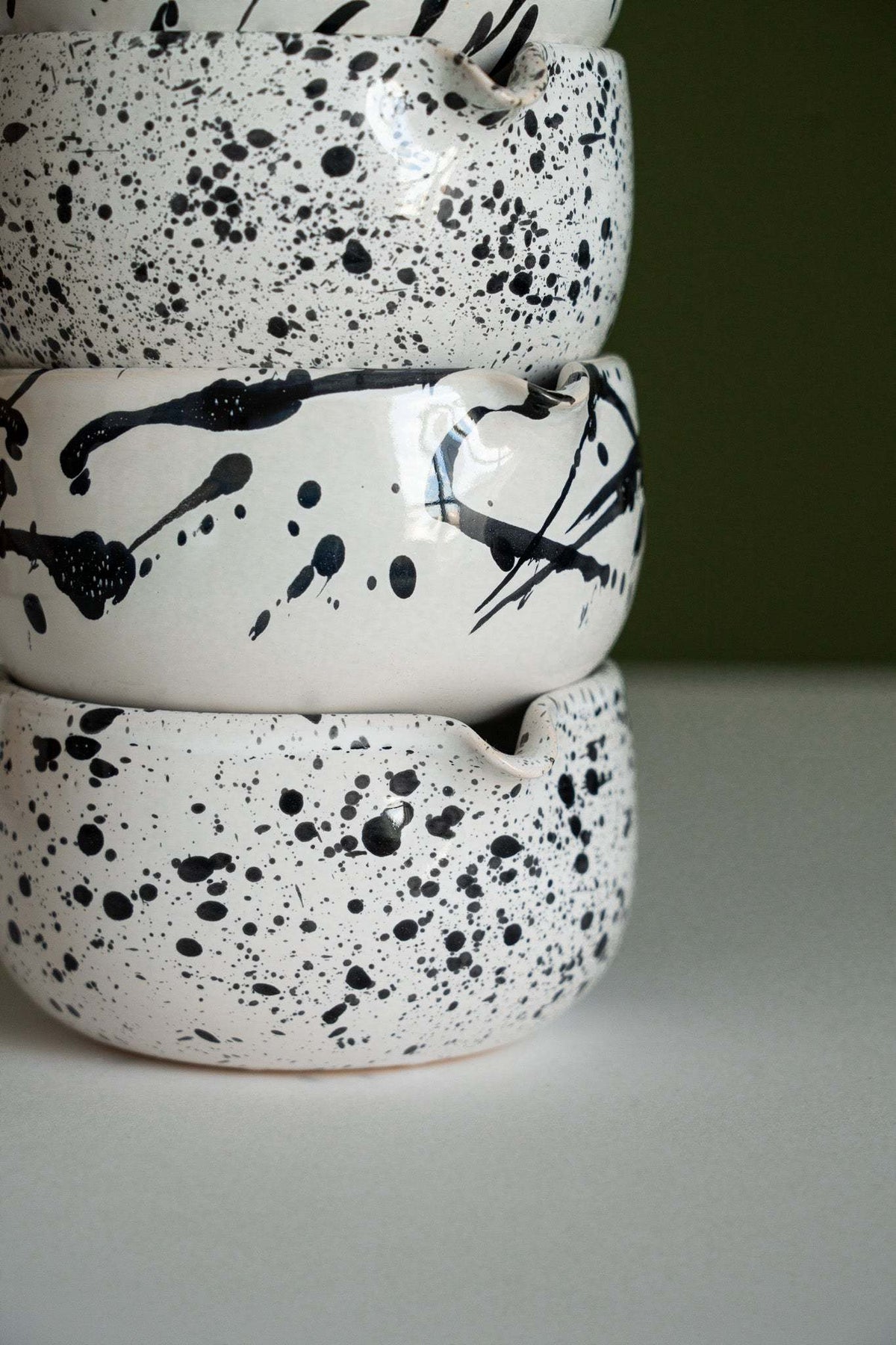 Handmade Matcha Bowl in white glazed stoneware, with bold black speckles and expressive brushstroke patterns.