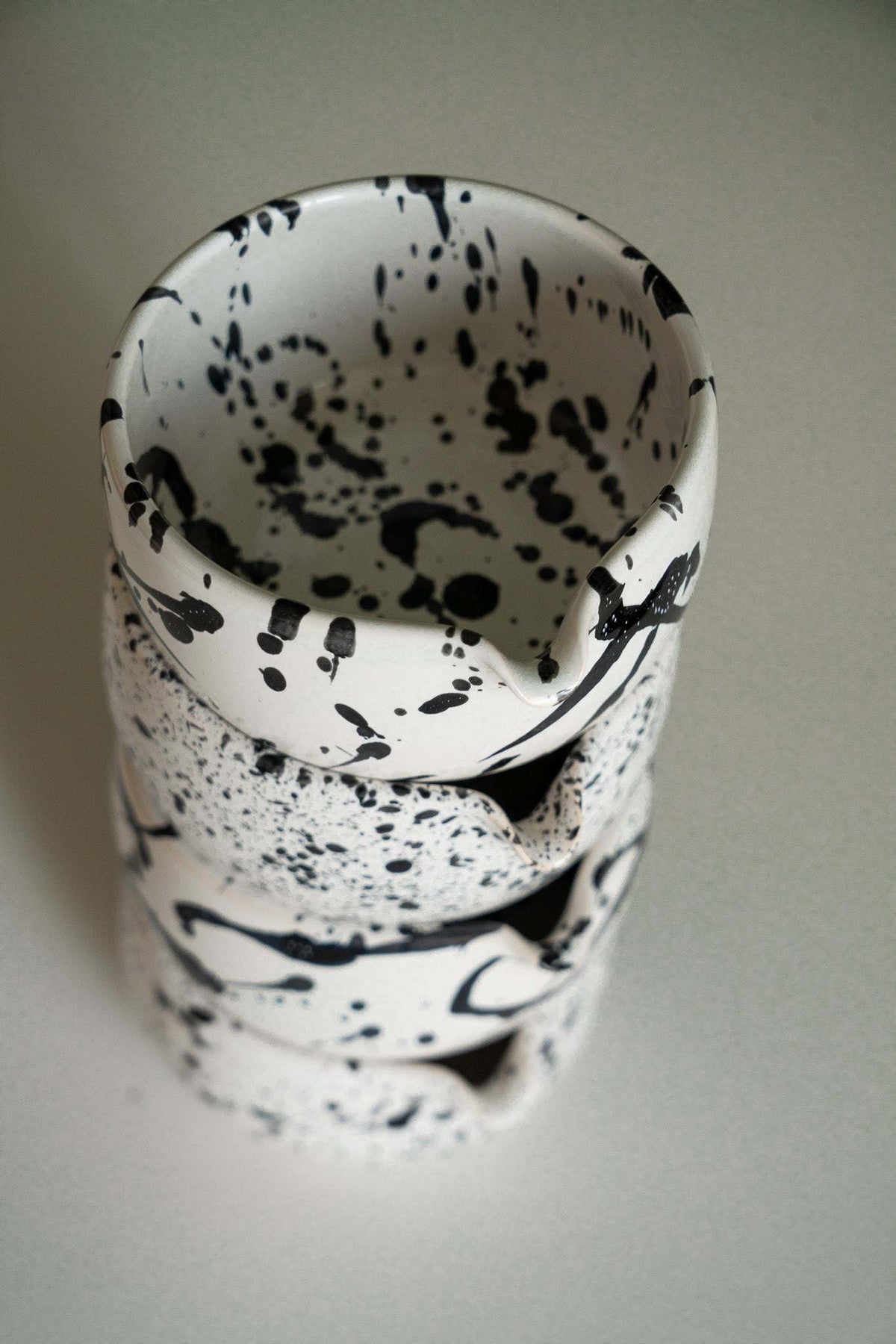 Handmade Matcha Bowl in white stoneware with bold black speckles and brushstroke markings, rounded shape and flared rim.