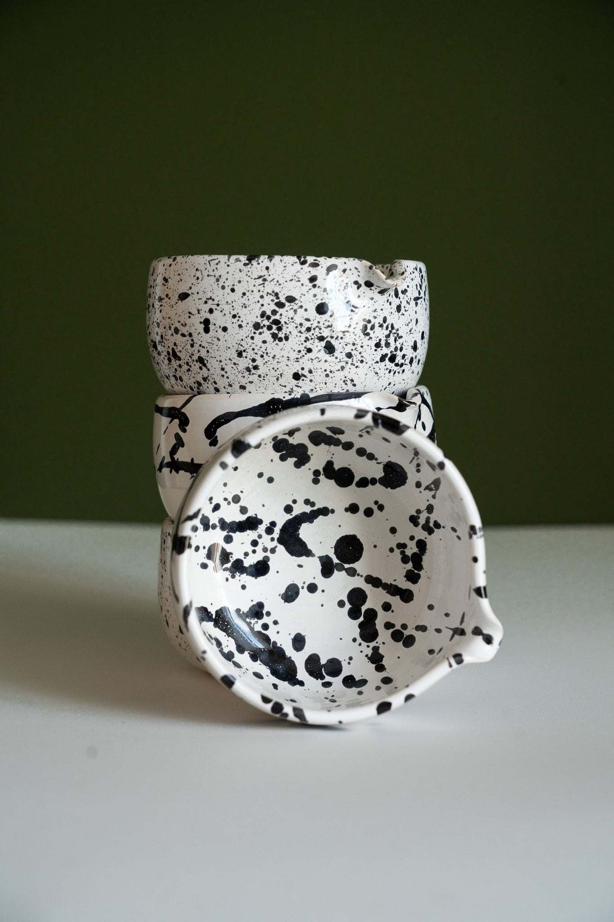 Handmade Matcha Bowl in white glazed ceramic, with bold black speckles and irregular brushstroke patterns.