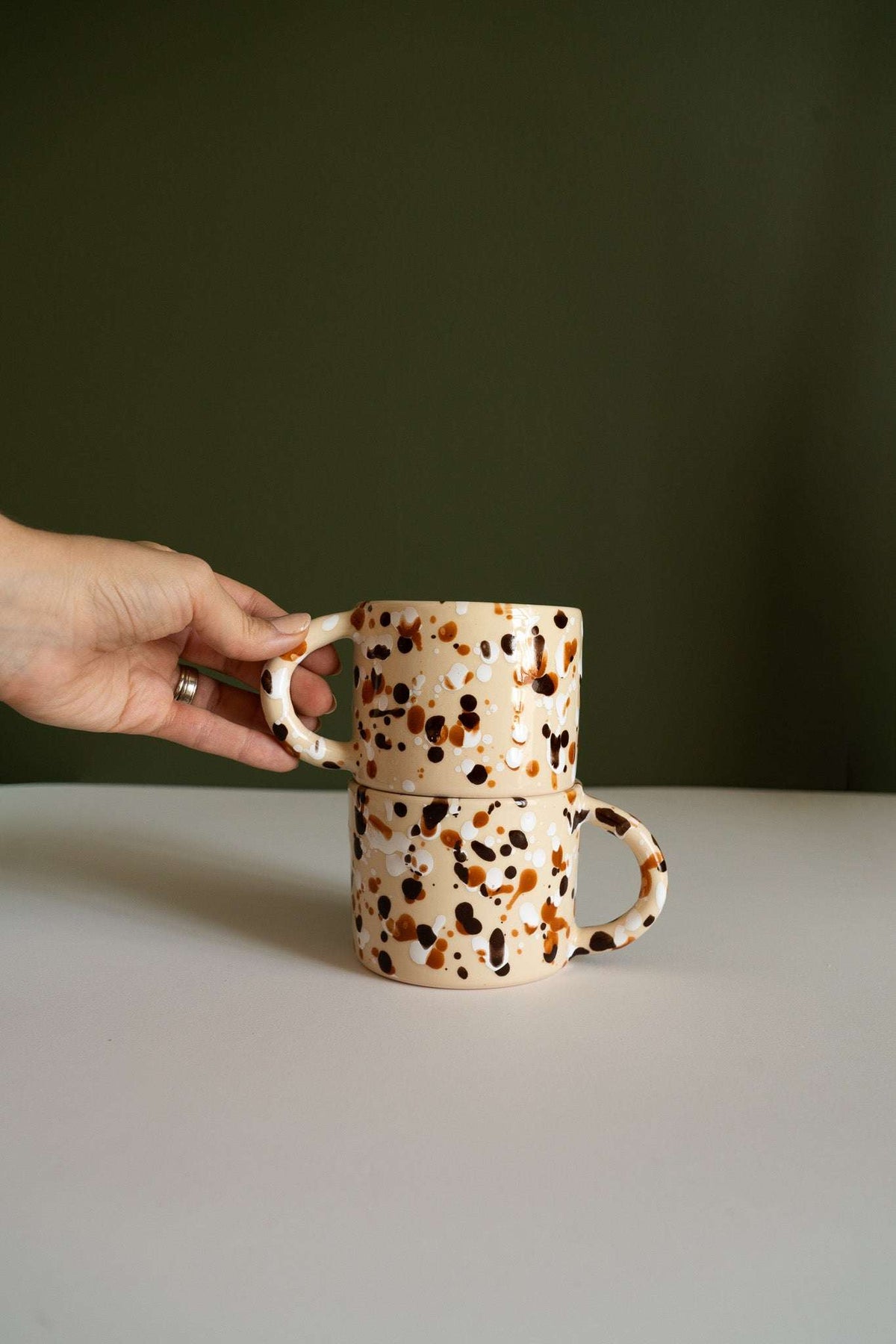 Splatter Stoneware Mug in cream ceramic with glossy brown and black speckles, straight sides and rounded handle.