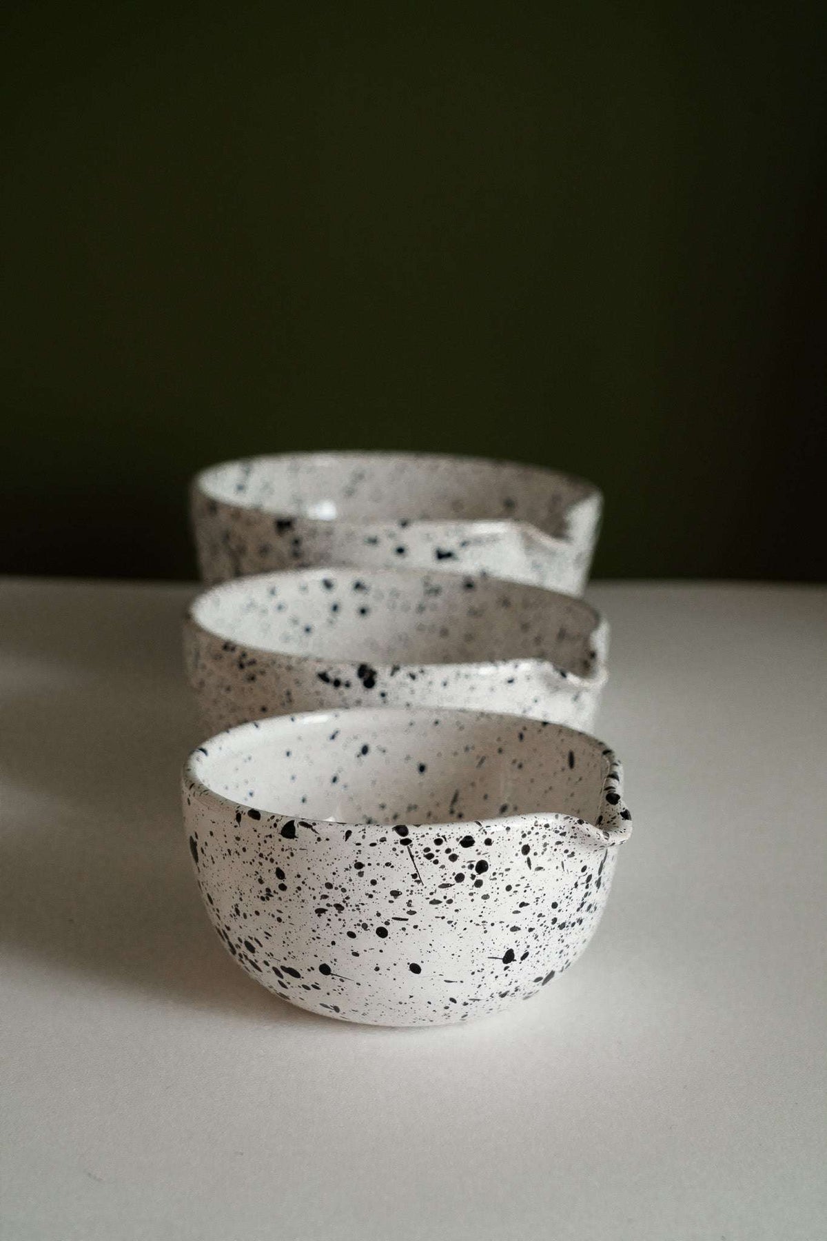 Deep stoneware mixing and serving bowls with pour spouts and speckled artisanal finish nesting together