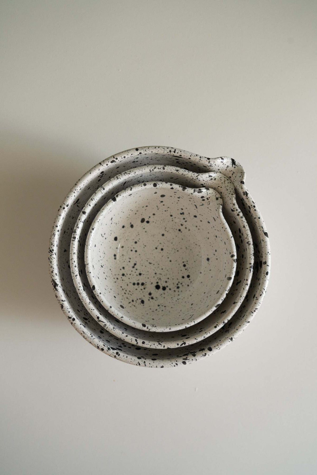 Deep stoneware mixing and serving nesting bowl set with pour spouts and artisanal black speckled finish