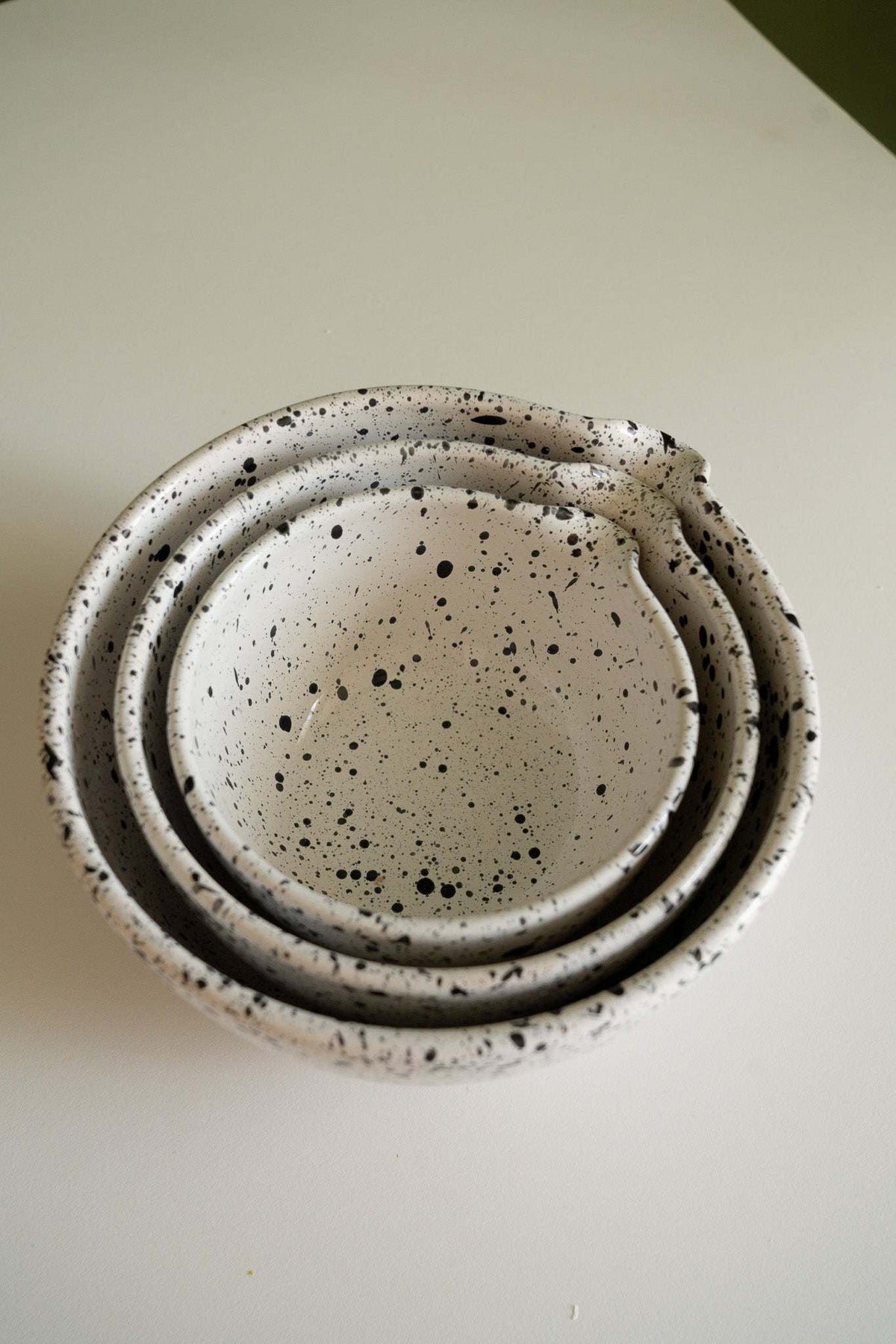 Set of deep stoneware mixing and serving bowls with pour spouts and artisanal speckled finish nesting together