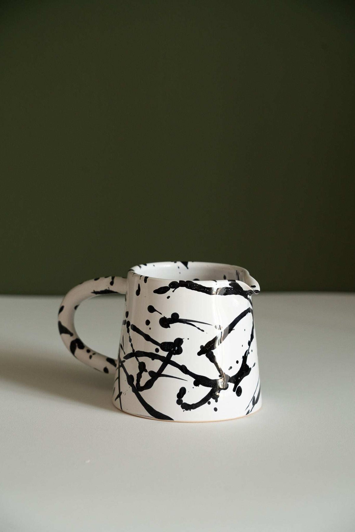 Handmade ceramic pour over coffee dripper and pitcher set in black and white stoneware
