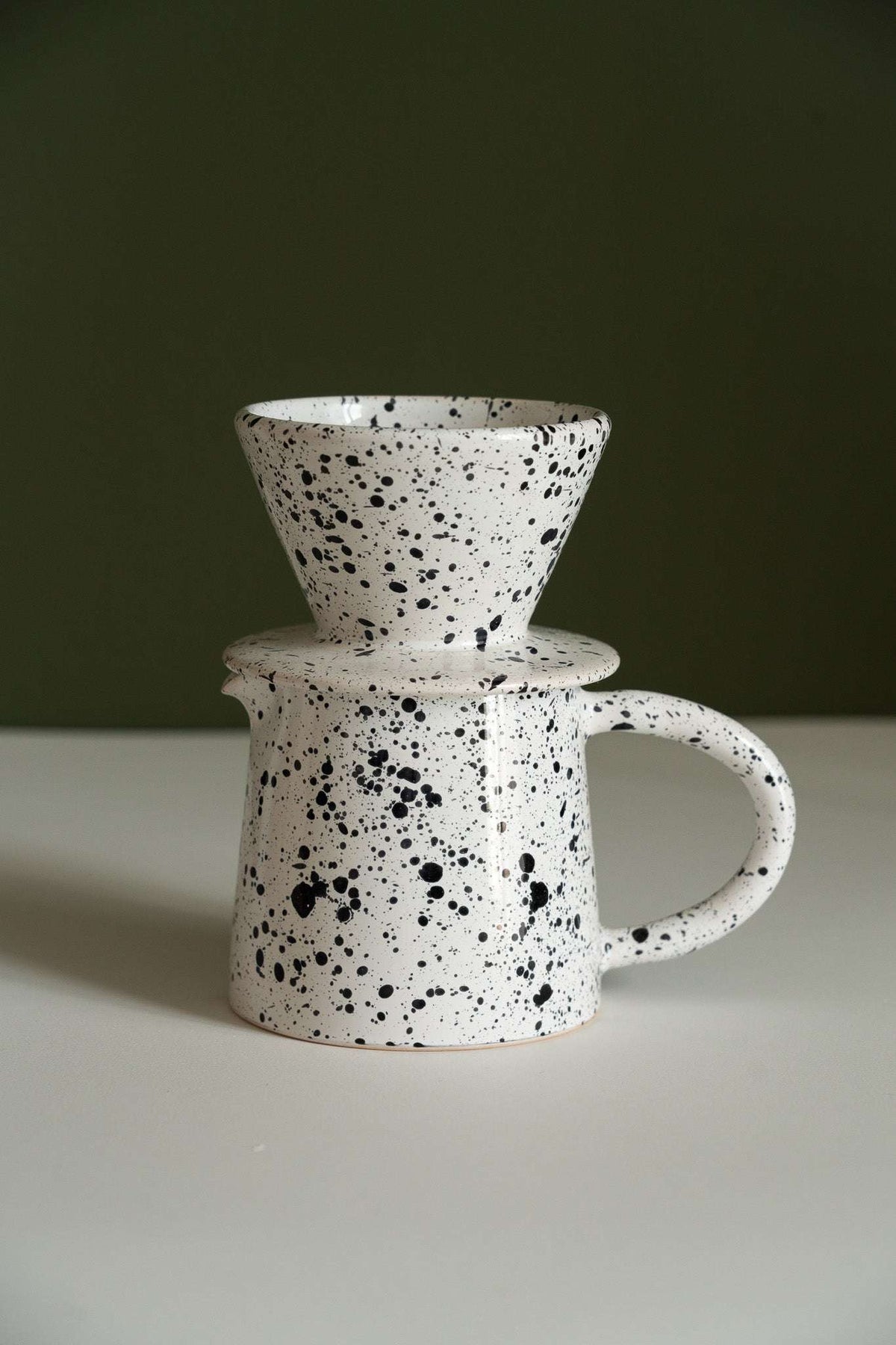 Handmade ceramic pour-over coffee dripper and pitcher set in black and white stoneware