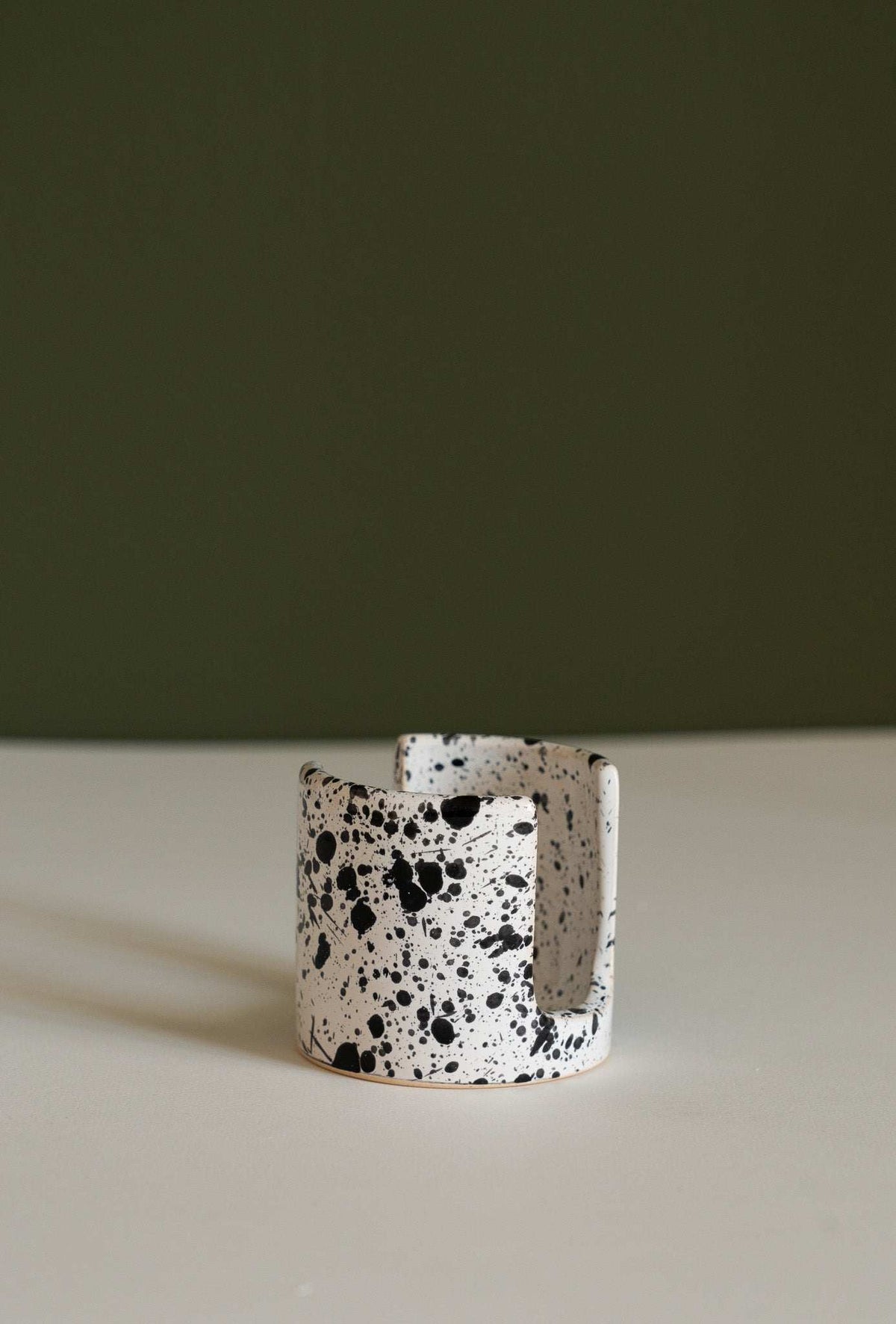 Handmade ceramic sponge holder with carved scallop design for kitchen sink.