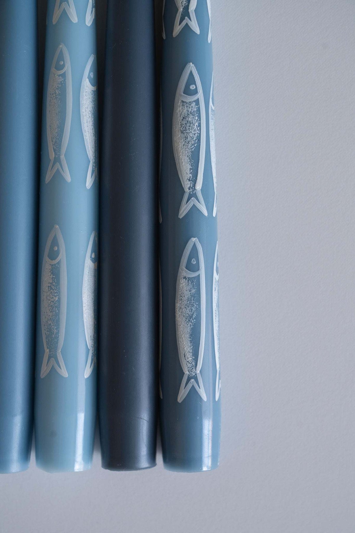 Hand-painted taper candle set with blue sardine illustrations for coastal decor