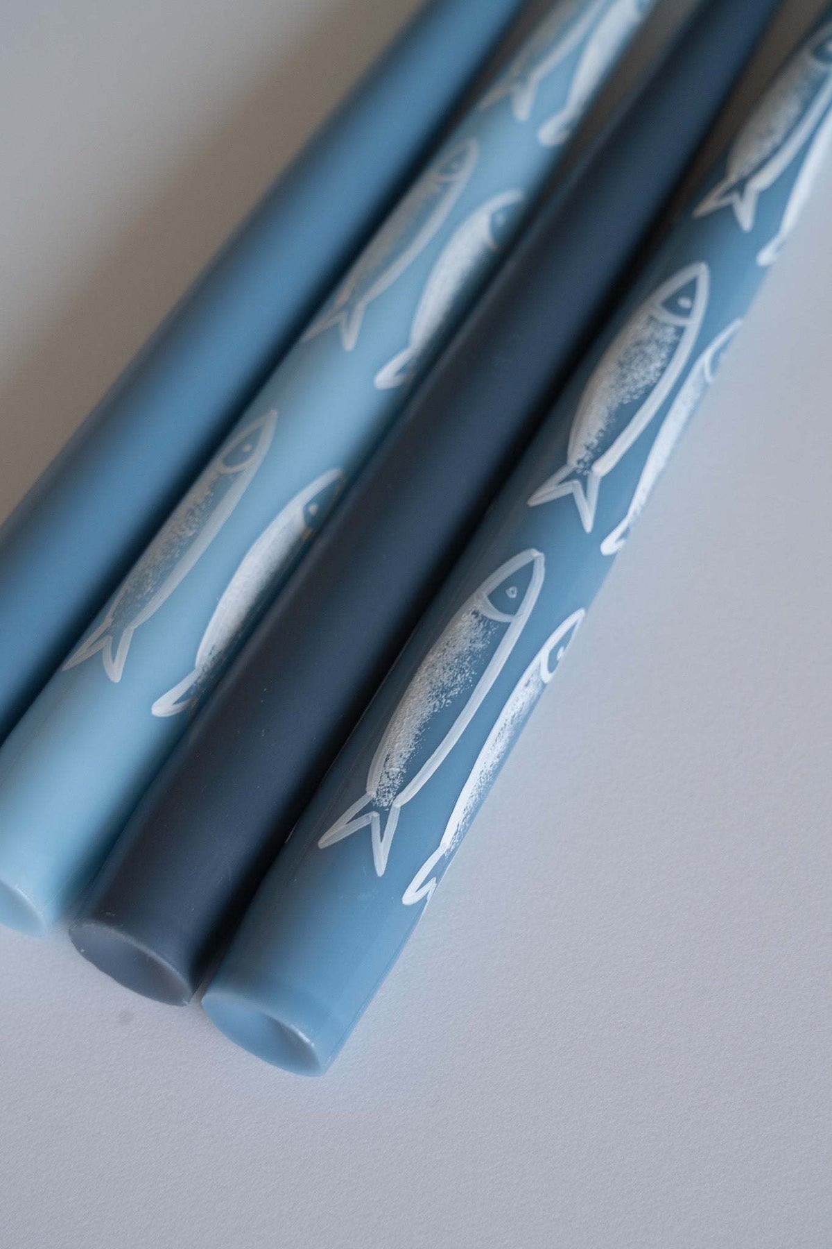 Hand-painted taper candle set with blue sardine illustrations for coastal decor